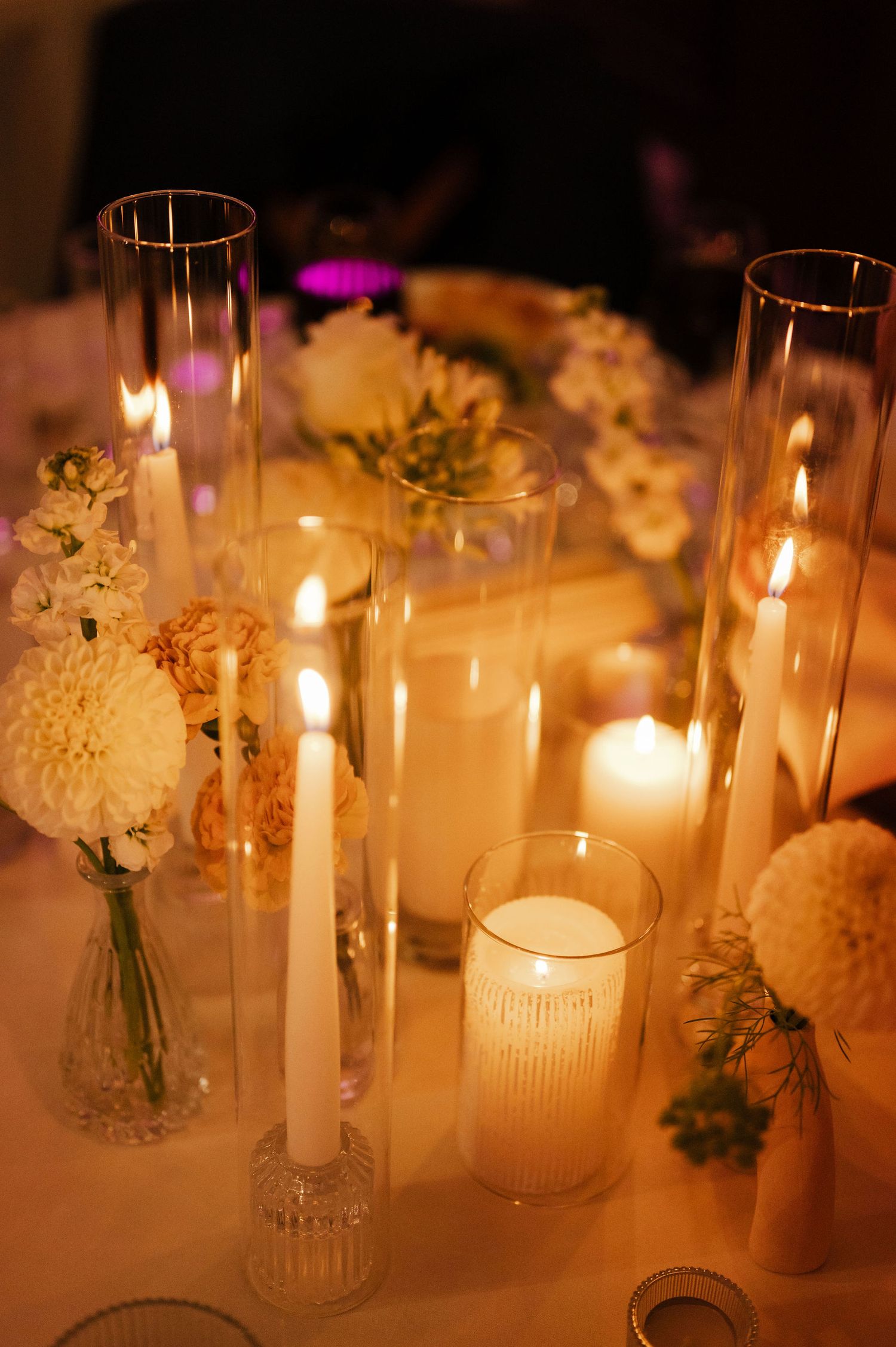 Elegant table decorations with white candles and floral centerpieces creating romantic ambiance.