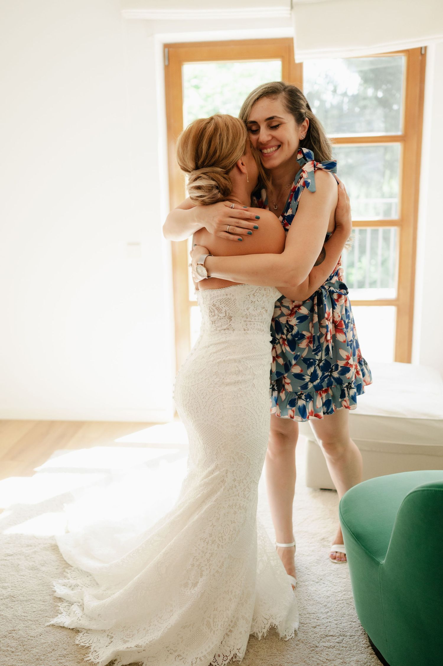 Two people share an emotional embrace, one wearing a white wedding dress.