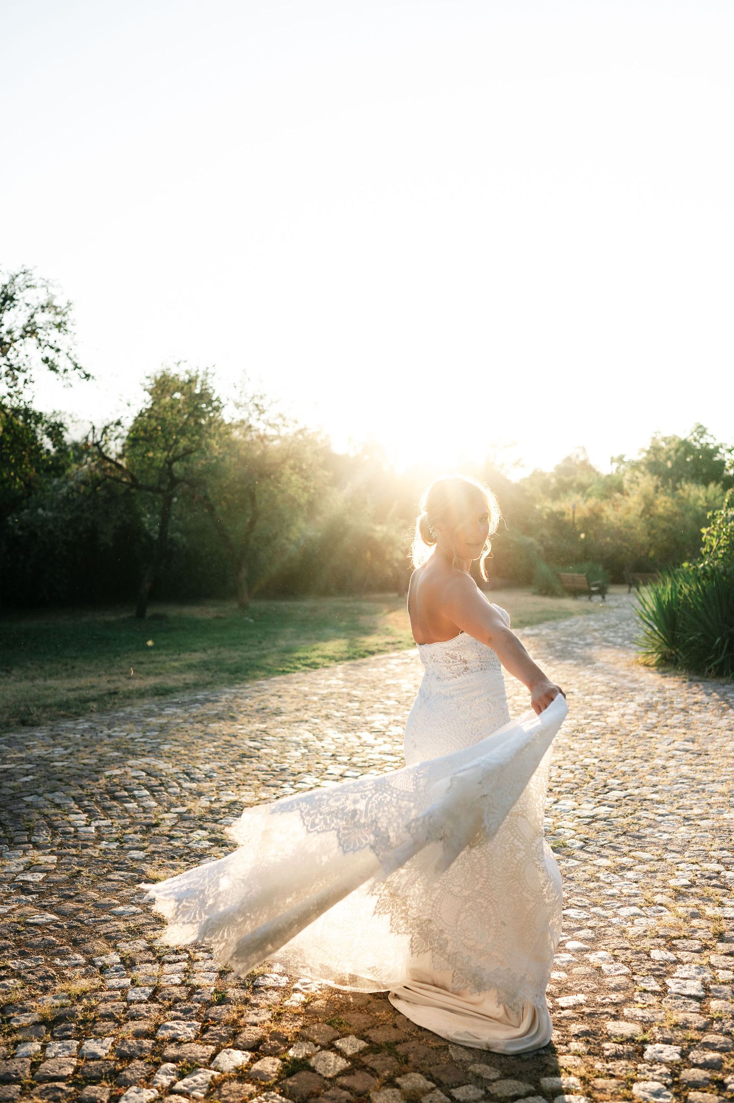 Ethereal bridal portrait with flowing dress captured in golden sunlight.