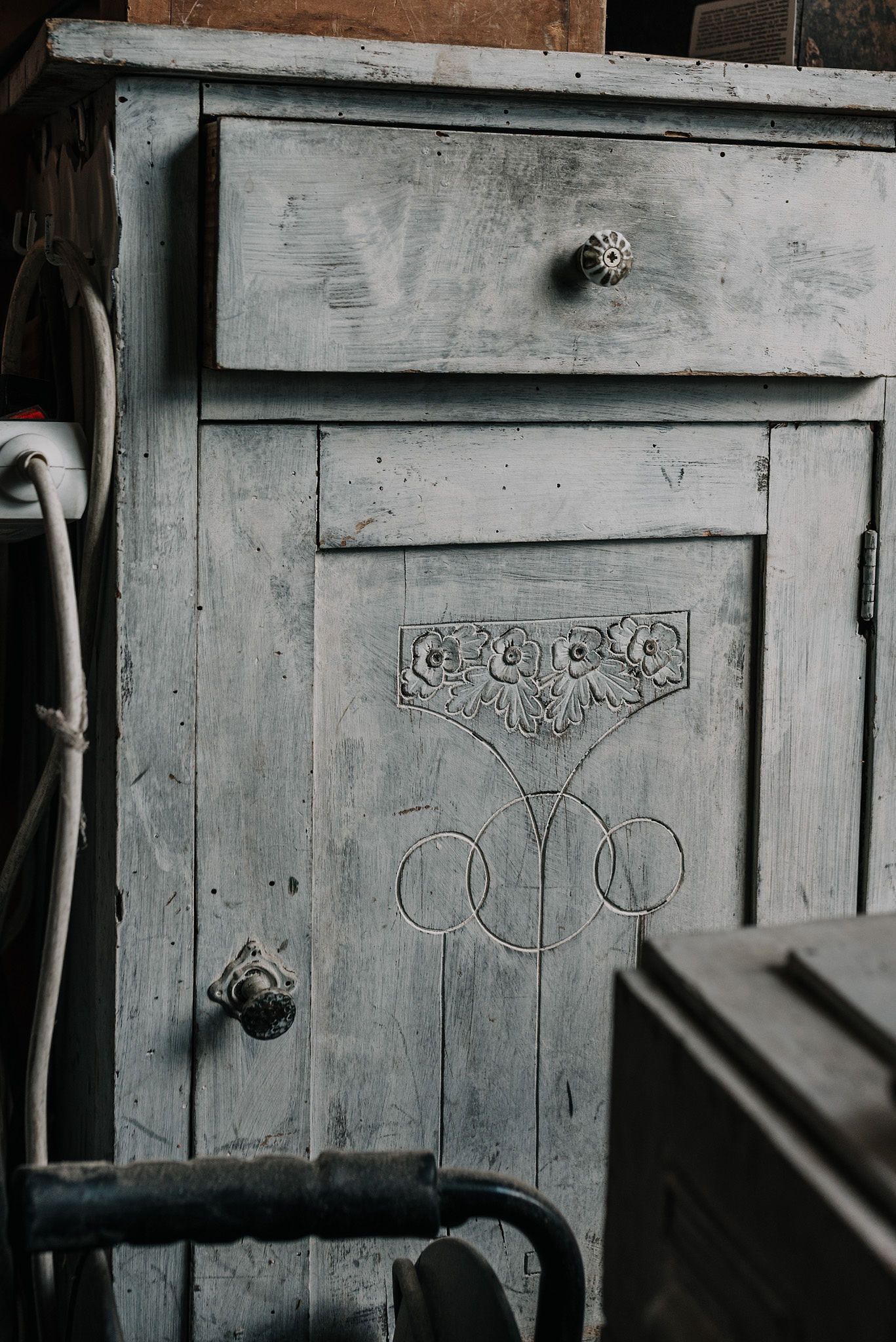 Weathered grey wooden panels with graffiti markings in dim lighting.