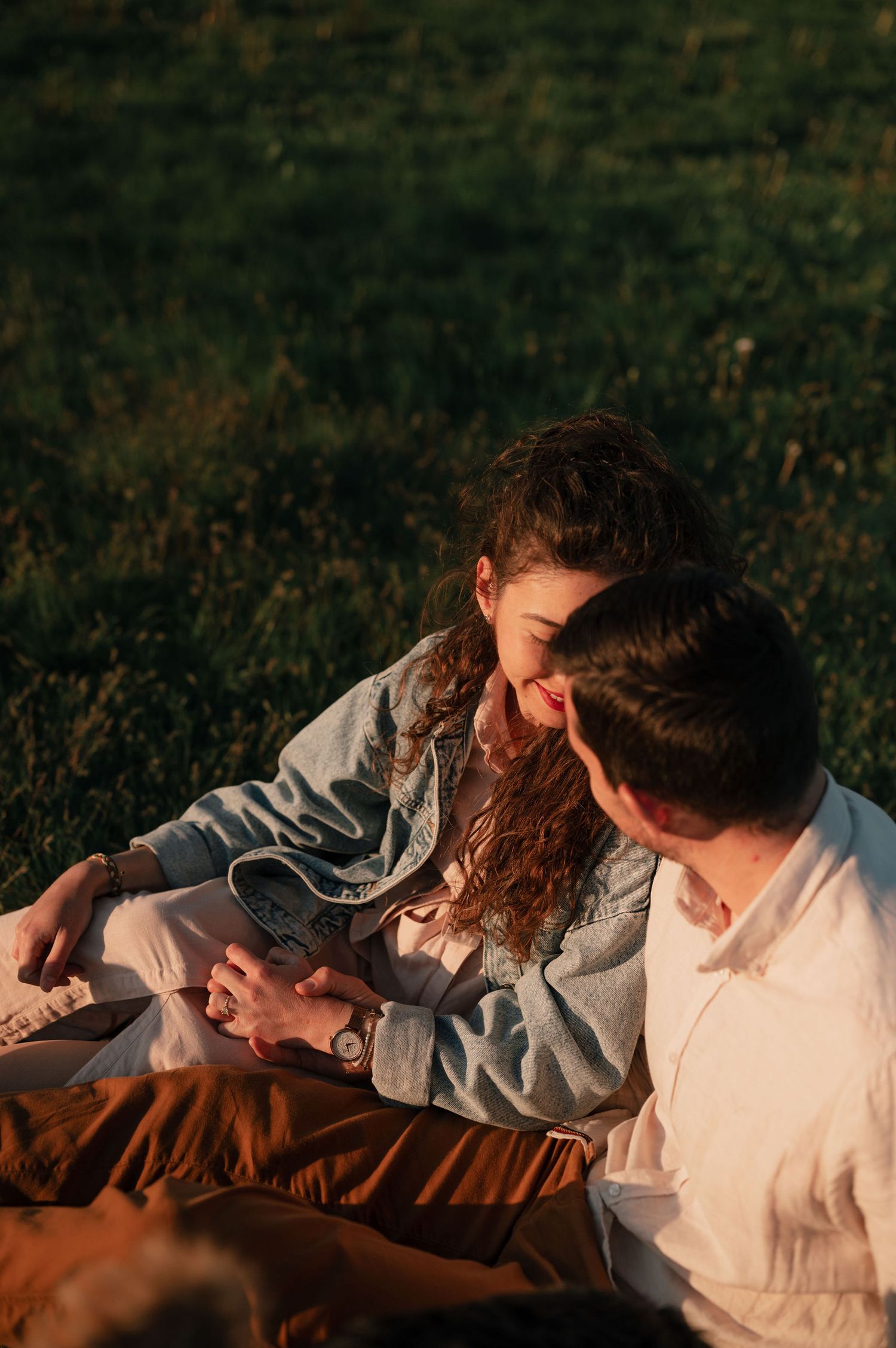 A series of candid shots showing people laying in grass during golden hour sunlight.
