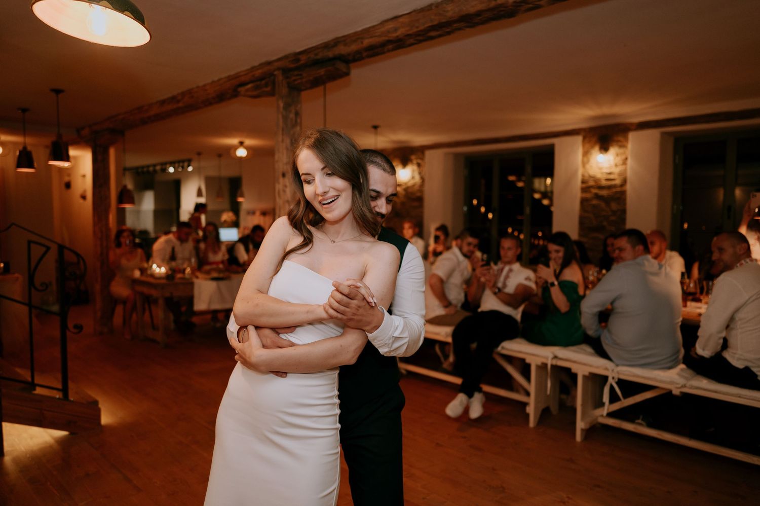 Wedding celebration featuring a dancing couple in an atmospheric reception space.