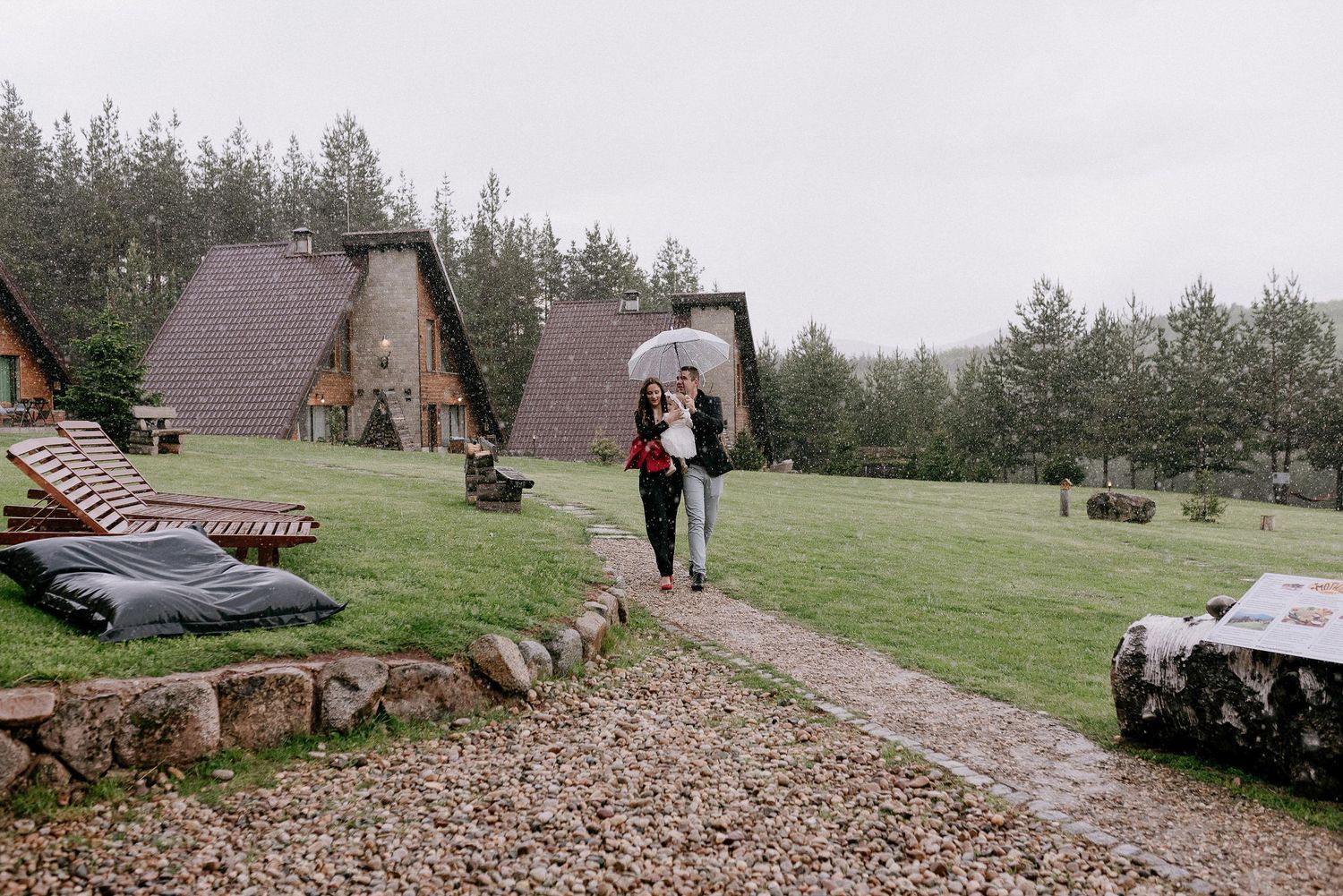 Stone pathway leads through a scenic outdoor venue surrounded by evergreen trees.
