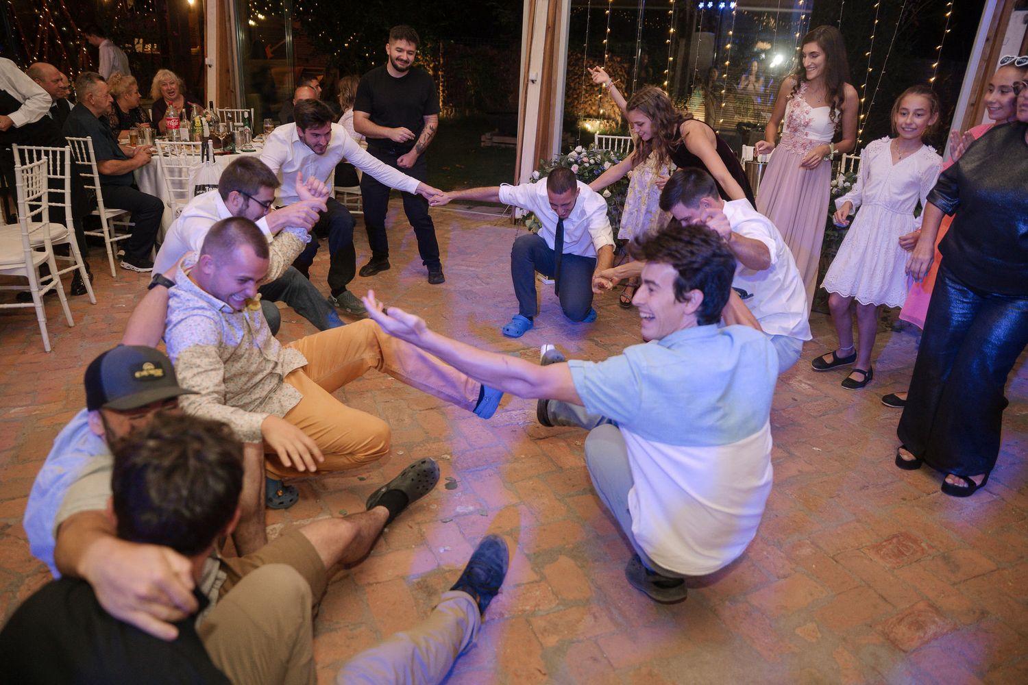Wedding guests dance and celebrate on the dance floor during a lively reception party.