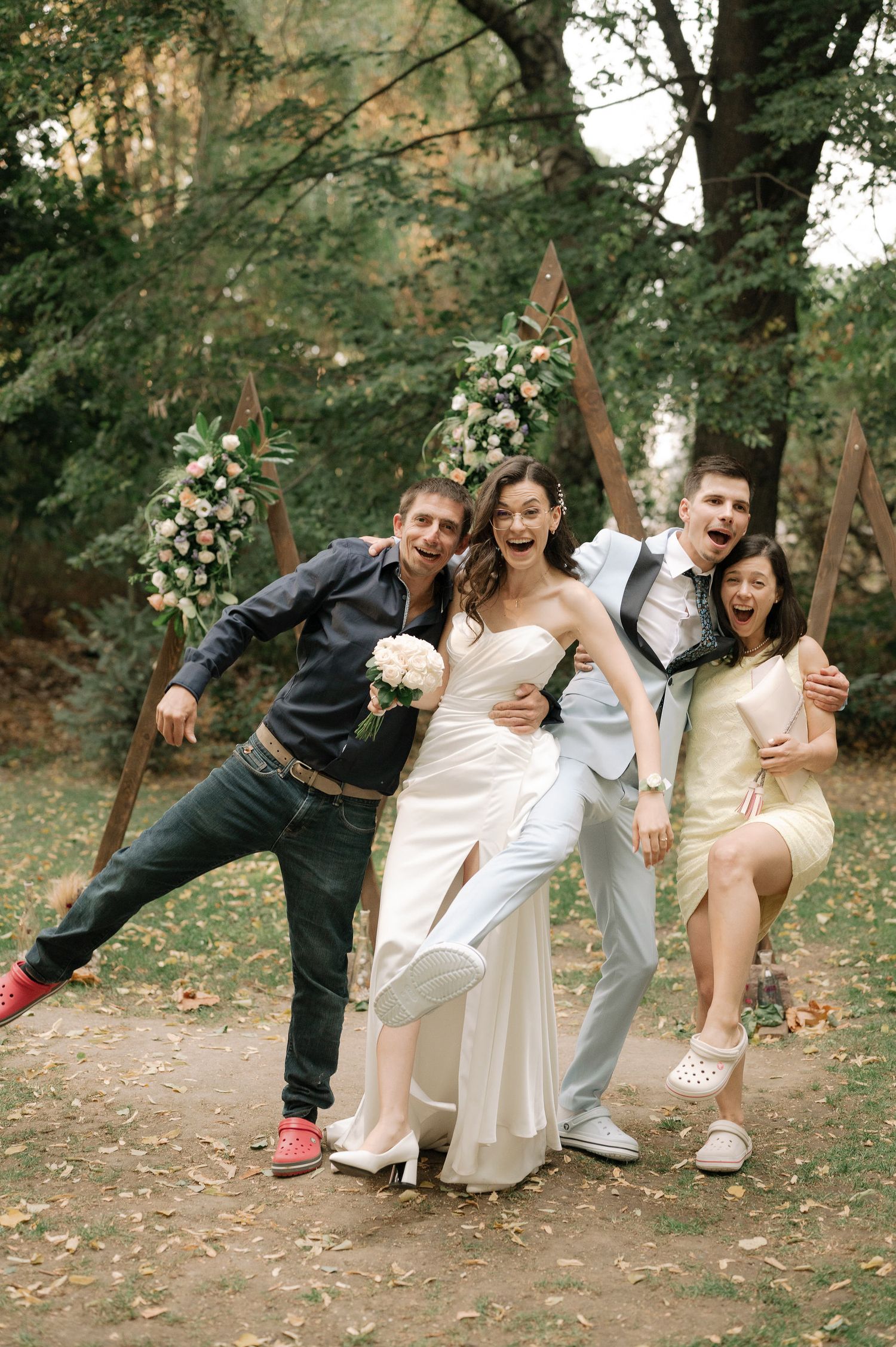 A playful sequence of wedding party photos showing four people posing and falling over together in an outdoor setting.
