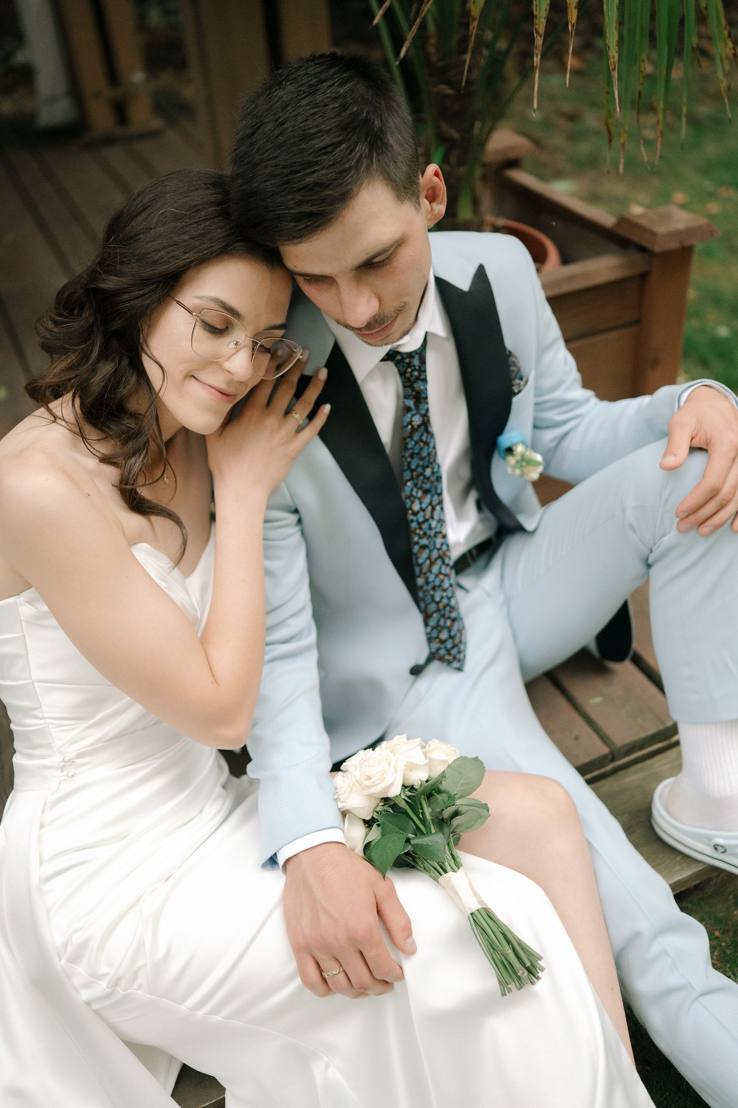 A romantic wedding photo series showing tender moments between a couple in white dress and light blue suit outdoors.