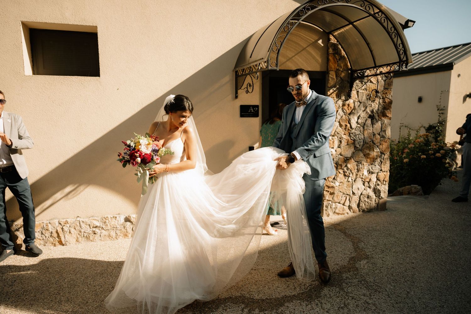 A sequence of wedding photos showing a bride in a white gown walking through a stone-walled corridor.
