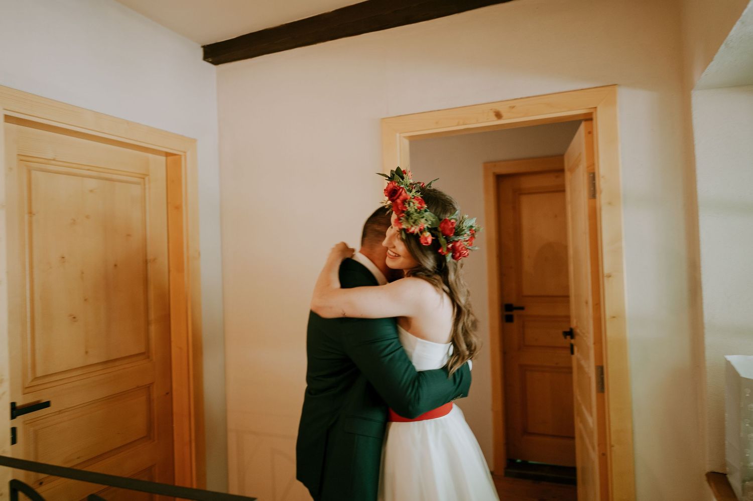 A couple embraces during their first look wedding moment in front of wooden doors.