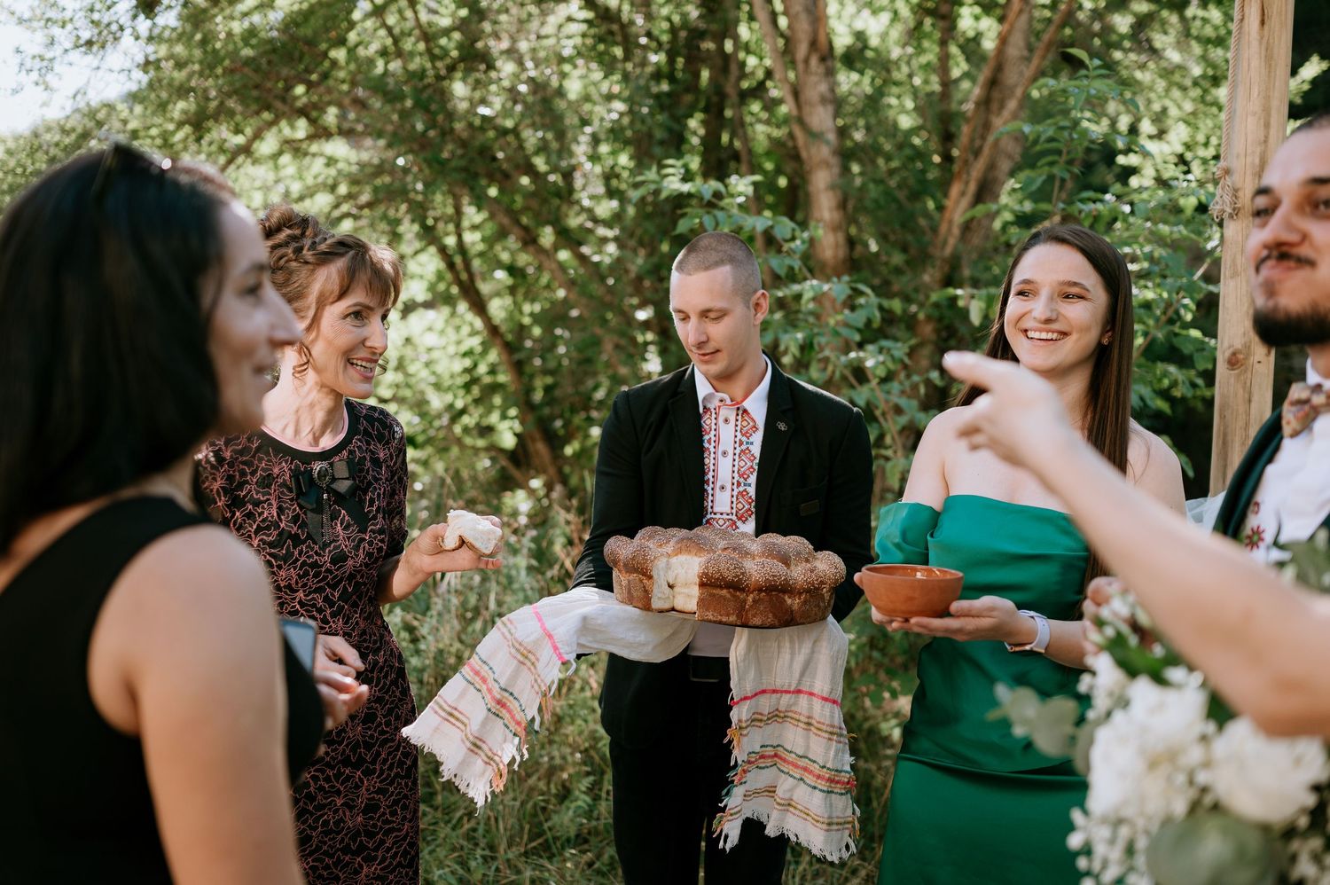 Outdoor wedding reception with guests mingling in garden setting.