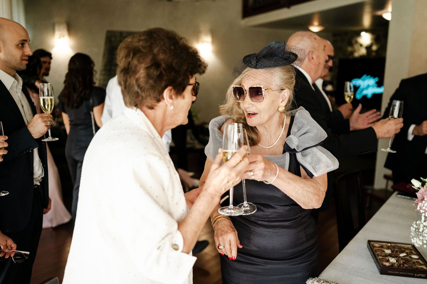 Guests enjoying drinks and conversation at an elegant evening wedding reception.
