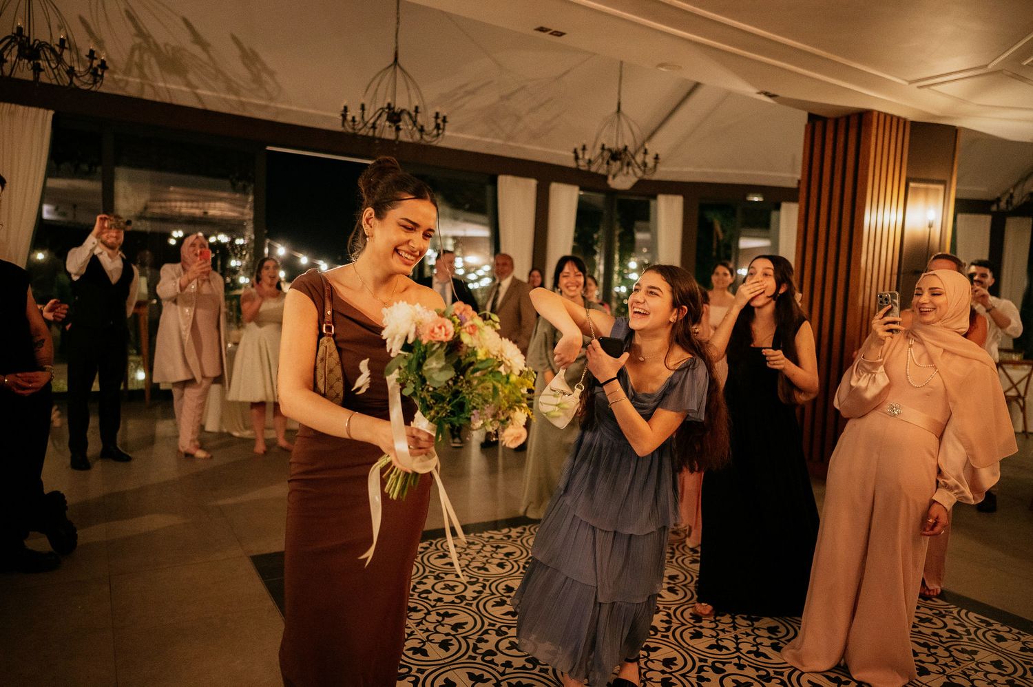 Wedding reception guests dancing and celebrating on the dance floor in an elegant venue.