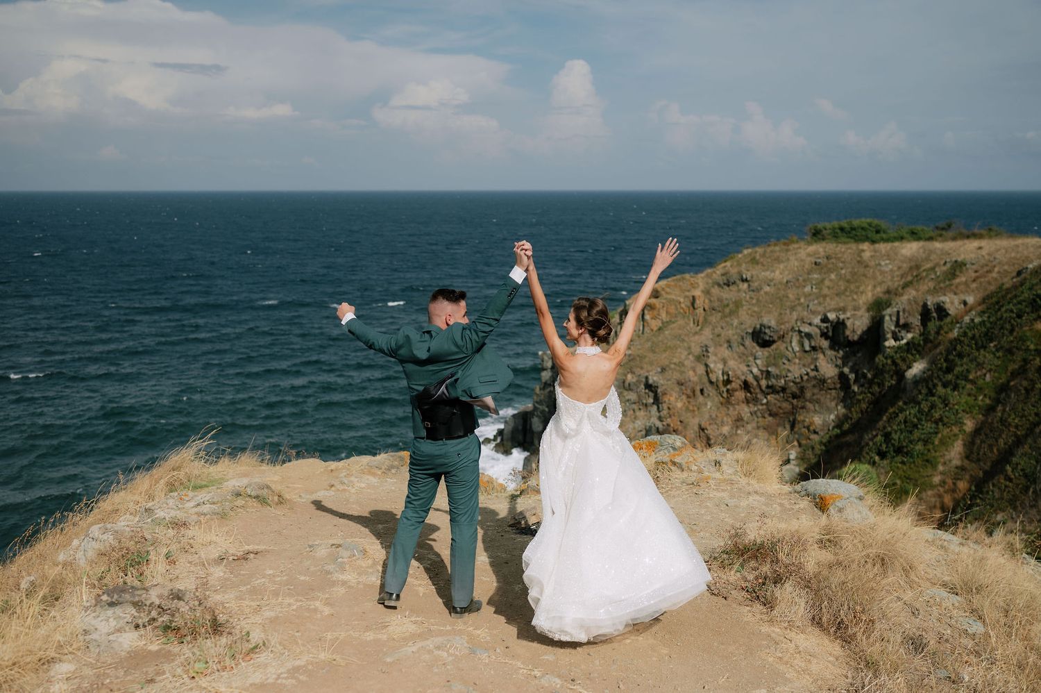 A joyful wedding celebration moment captured on a scenic coastal overlook.