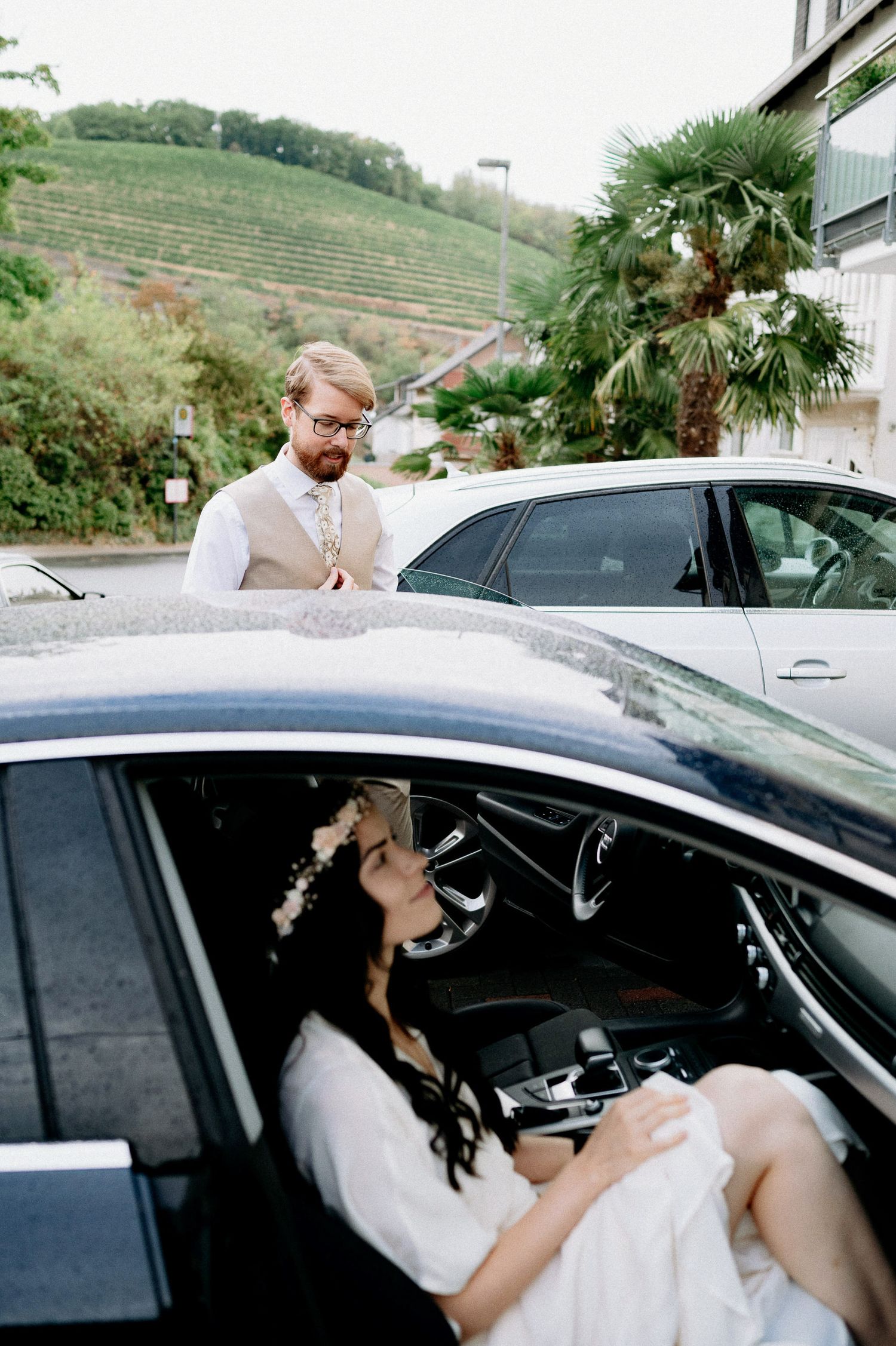 Candid moments captured of a bride relaxing in a car on her wedding day.