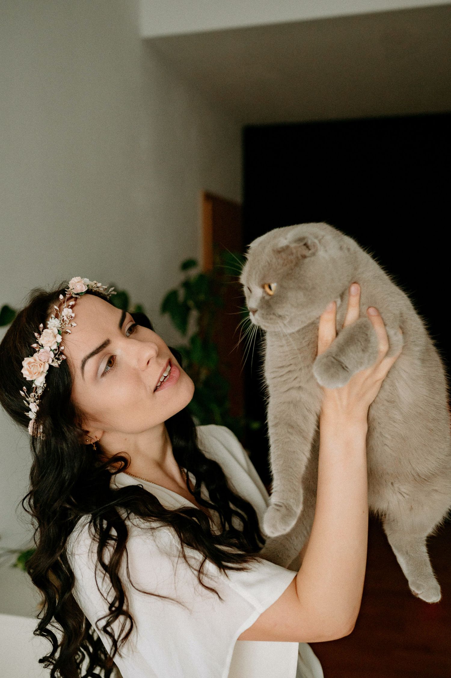 Intimate portraits with grey cat showing affectionate interaction in white attire.