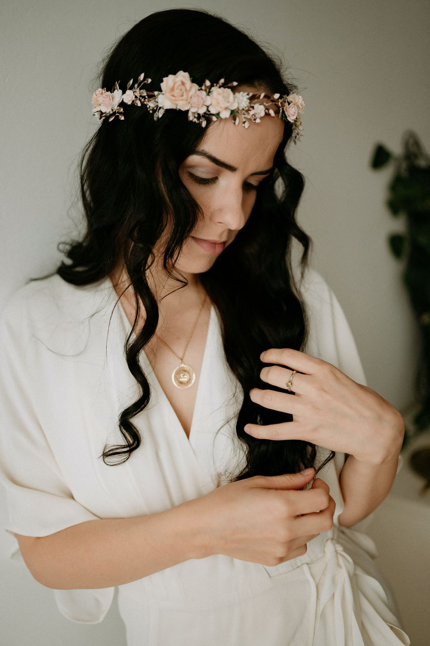 Soft bridal portrait with flowing white robe and dainty floral crown accessories.