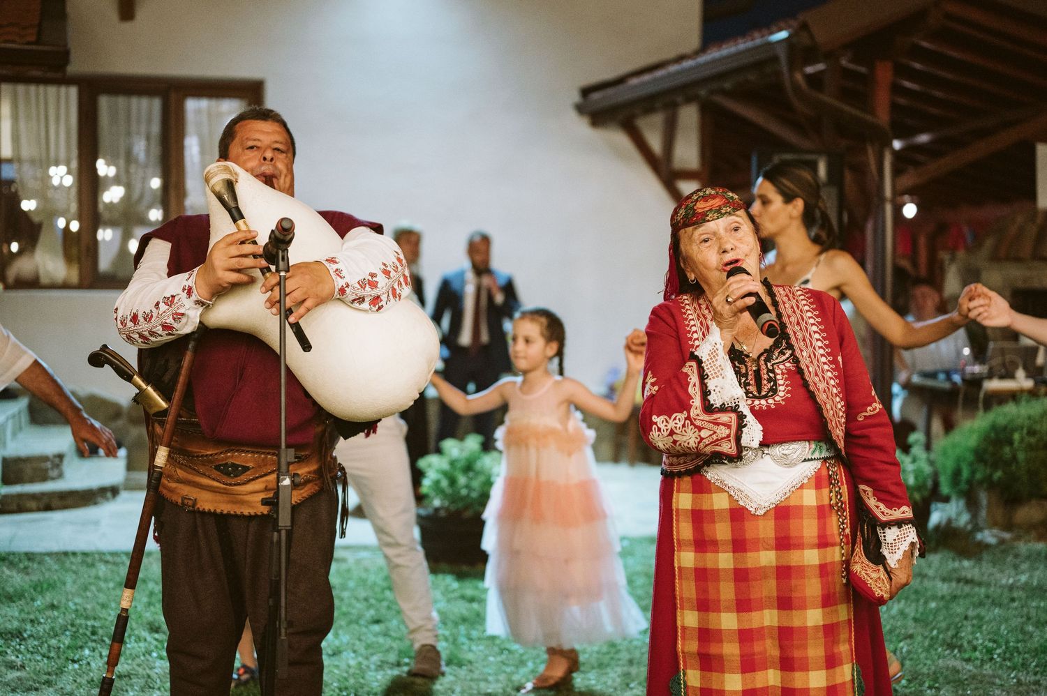 Wedding reception dancers in colorful attire enjoying traditional folk dancing.