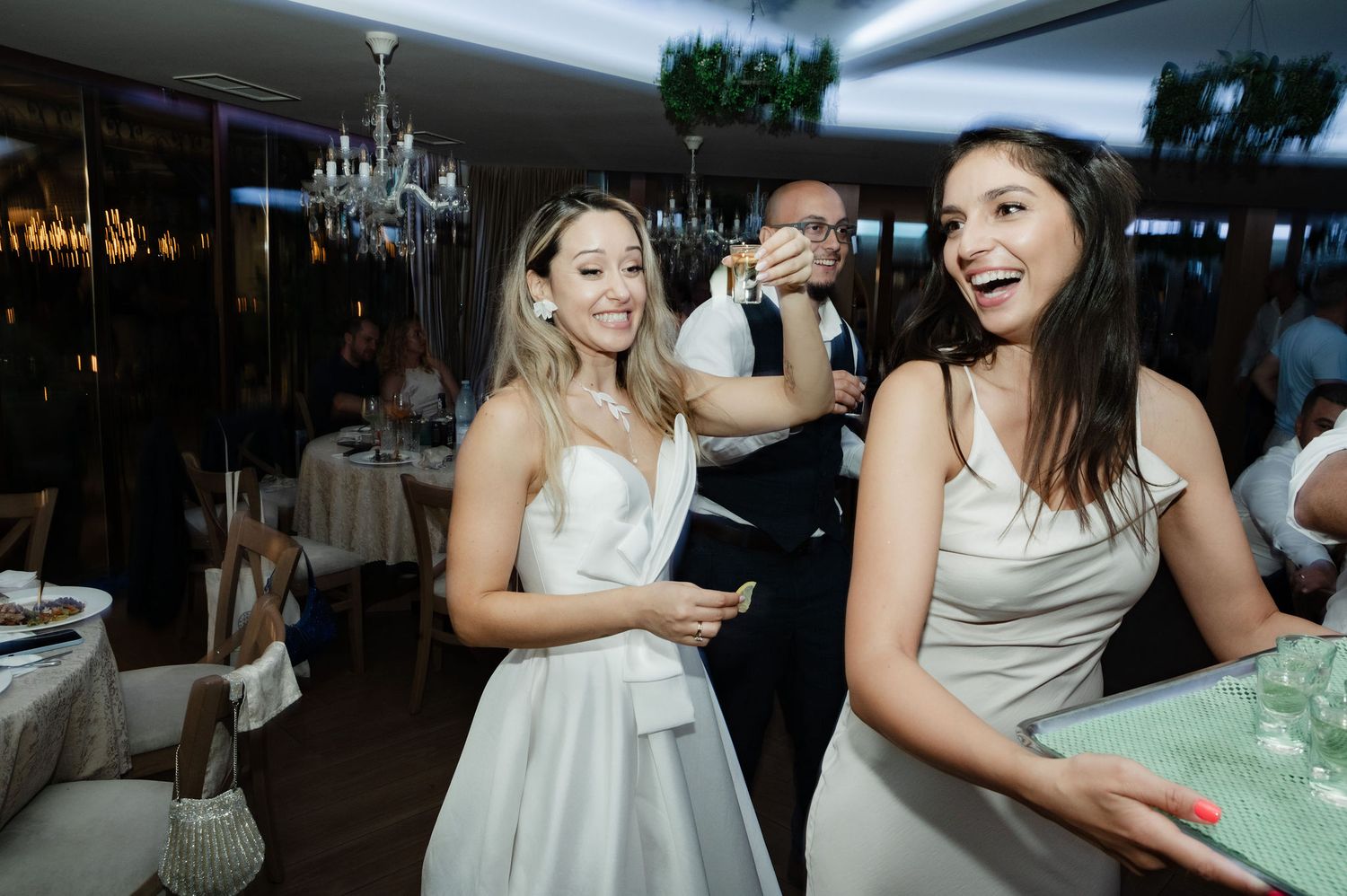 Wedding guests share joyful moments and laughter during an elegant reception celebration.