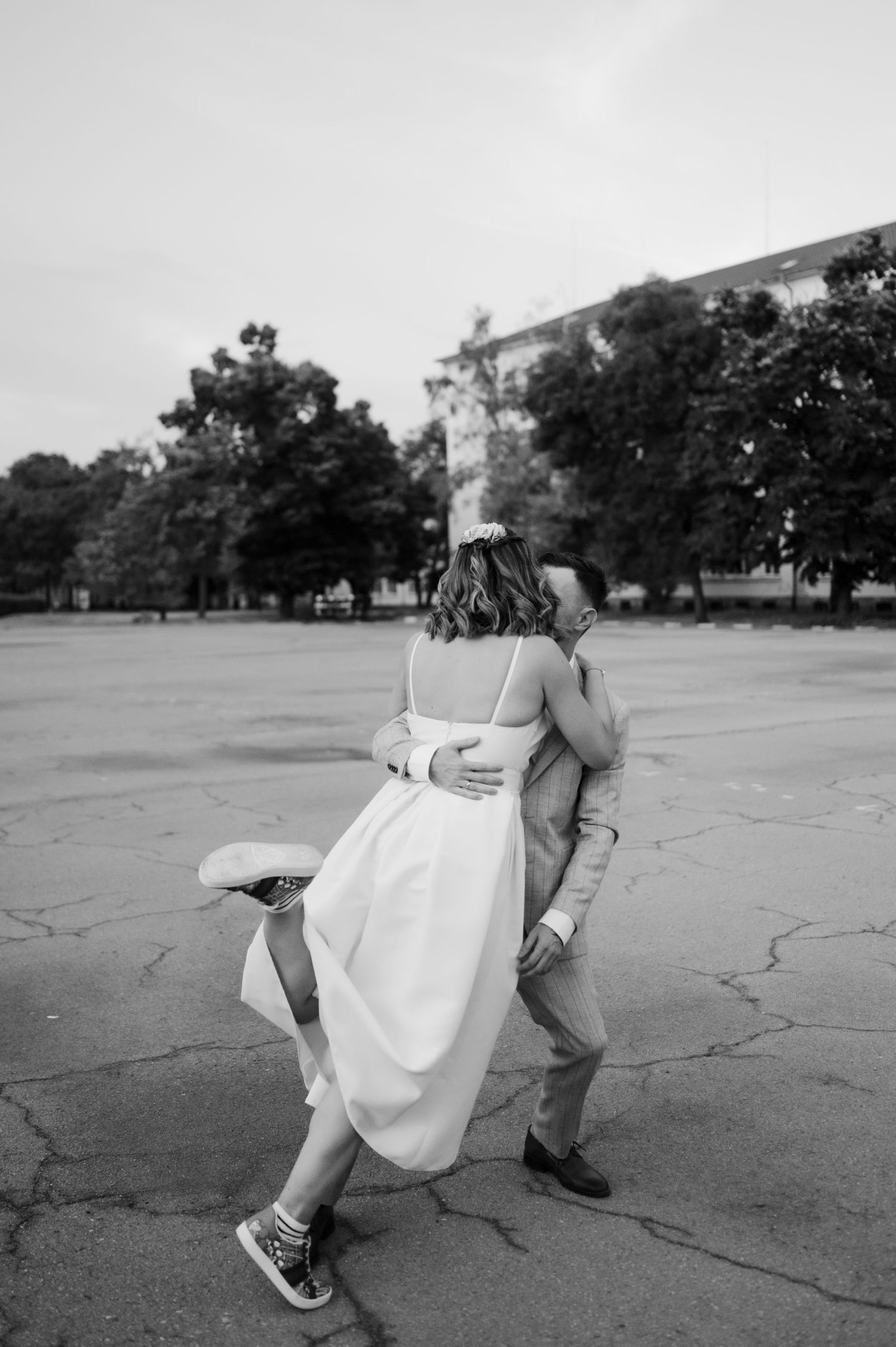 A sequence of black and white photos shows a person in white dress performing a breakdancing move on cracked pavement.