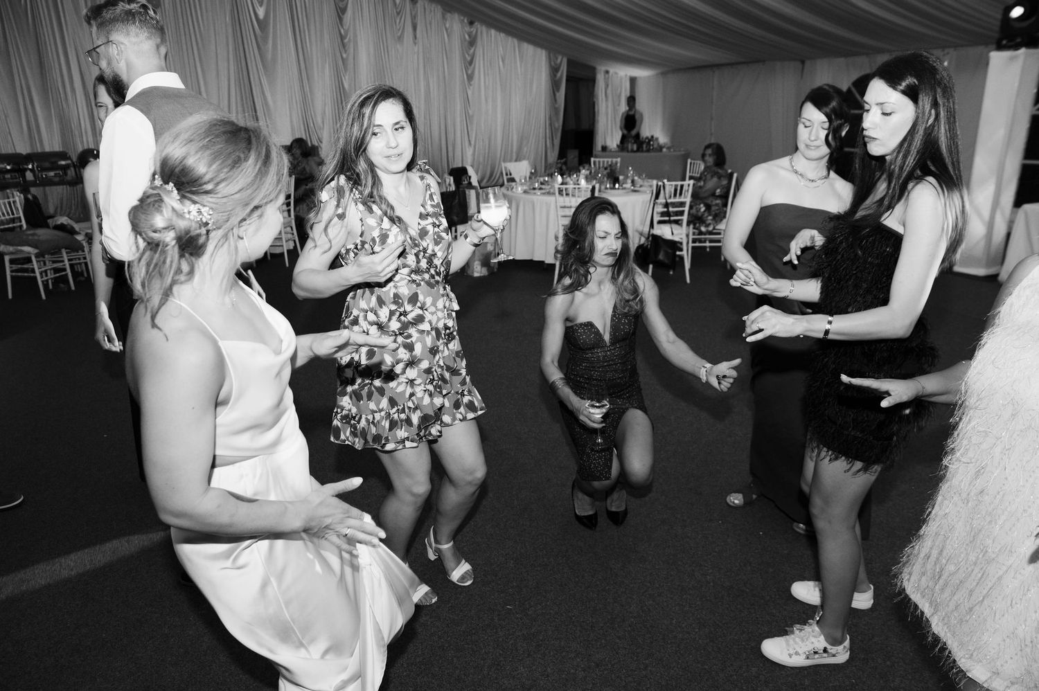 People dancing and socializing at a party or celebration in a black and white photograph.