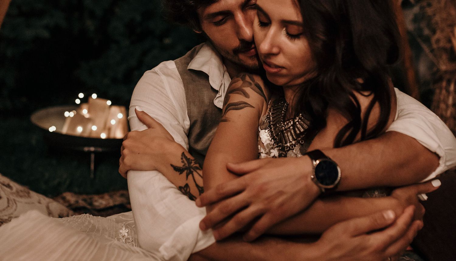 A romantic couple embraces intimately in warm lighting with soft focus and moody atmosphere.