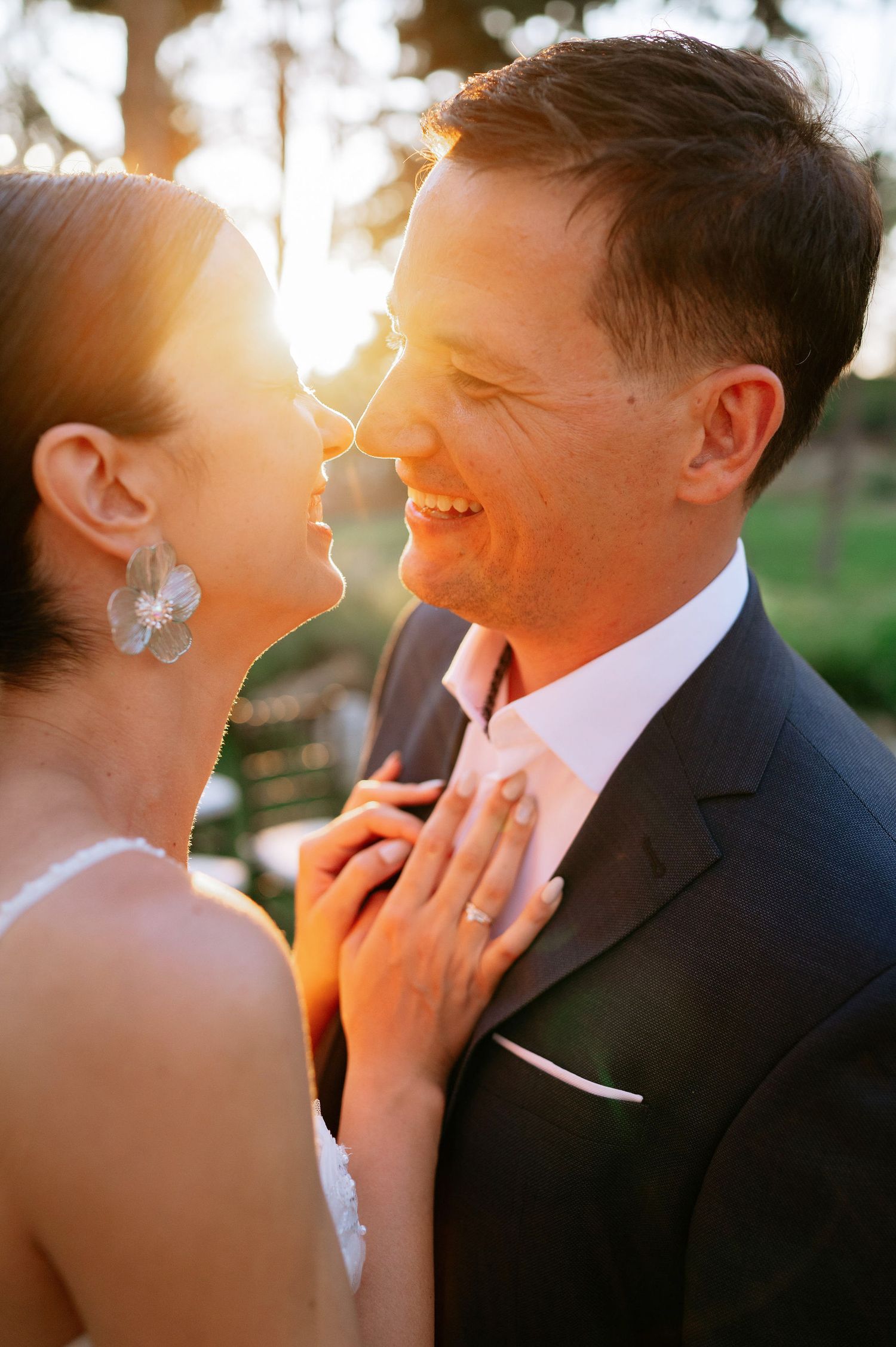 Intimate wedding portrait showing tender moments between newlyweds in warm sunset lighting.