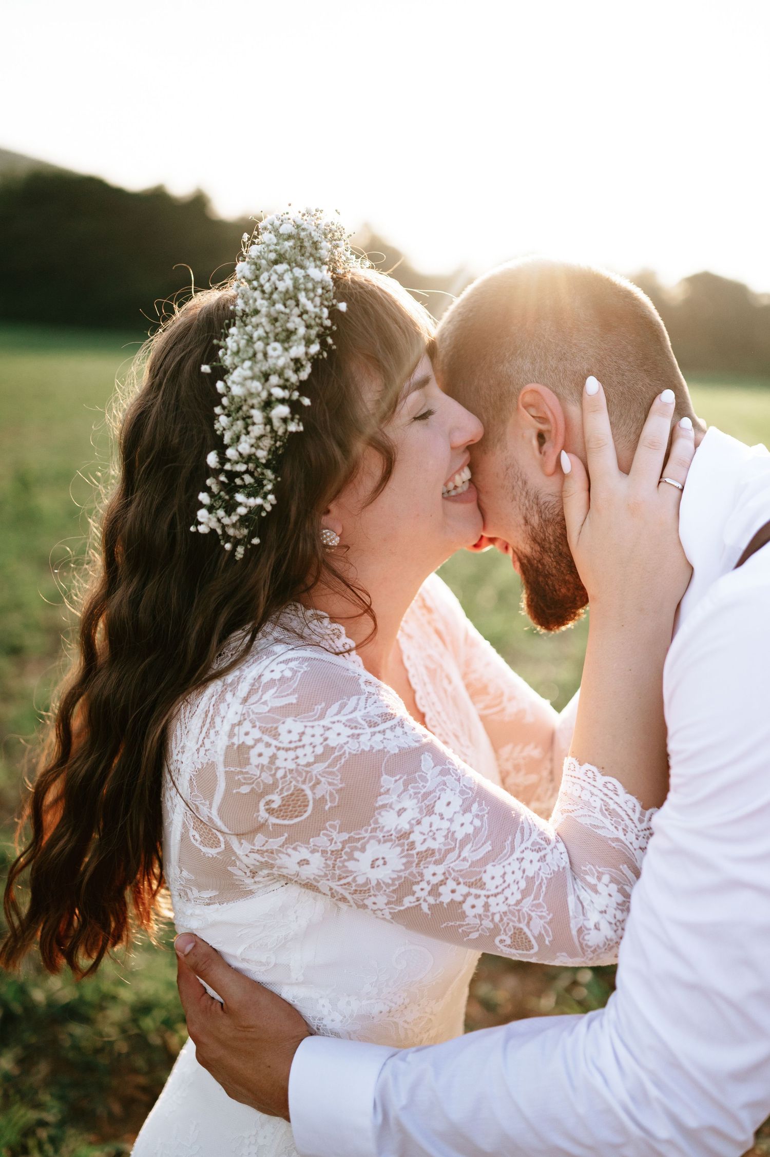 Intimate wedding portrait captures couple's loving embrace in warm evening sunlight.