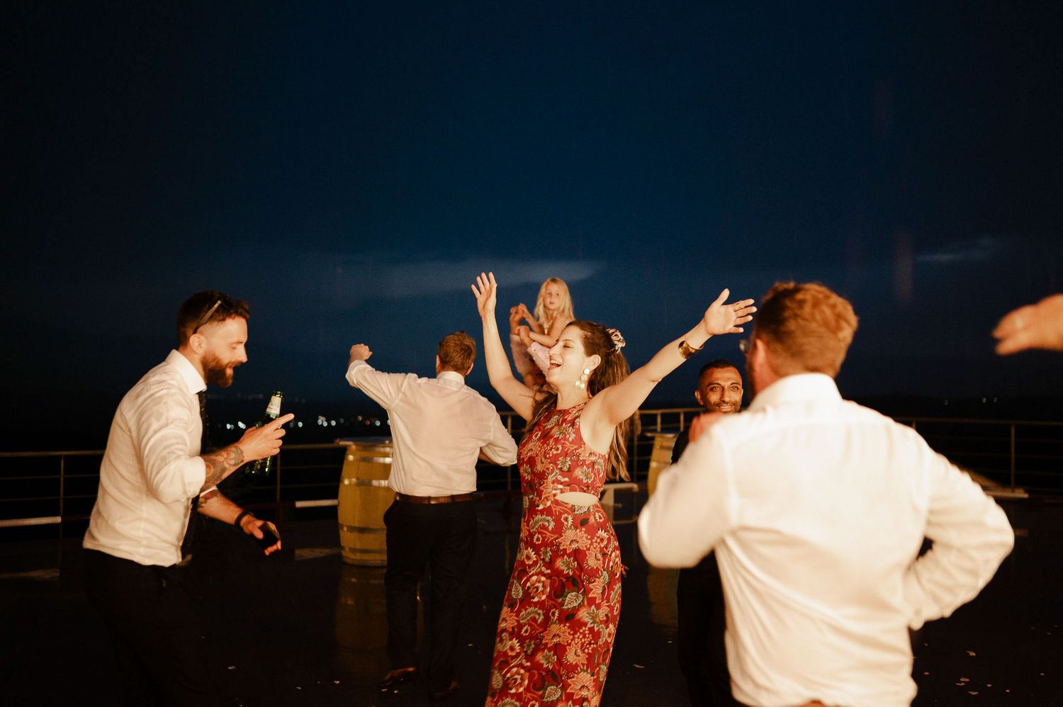 Party guests dancing in formal attire at an outdoor evening event.