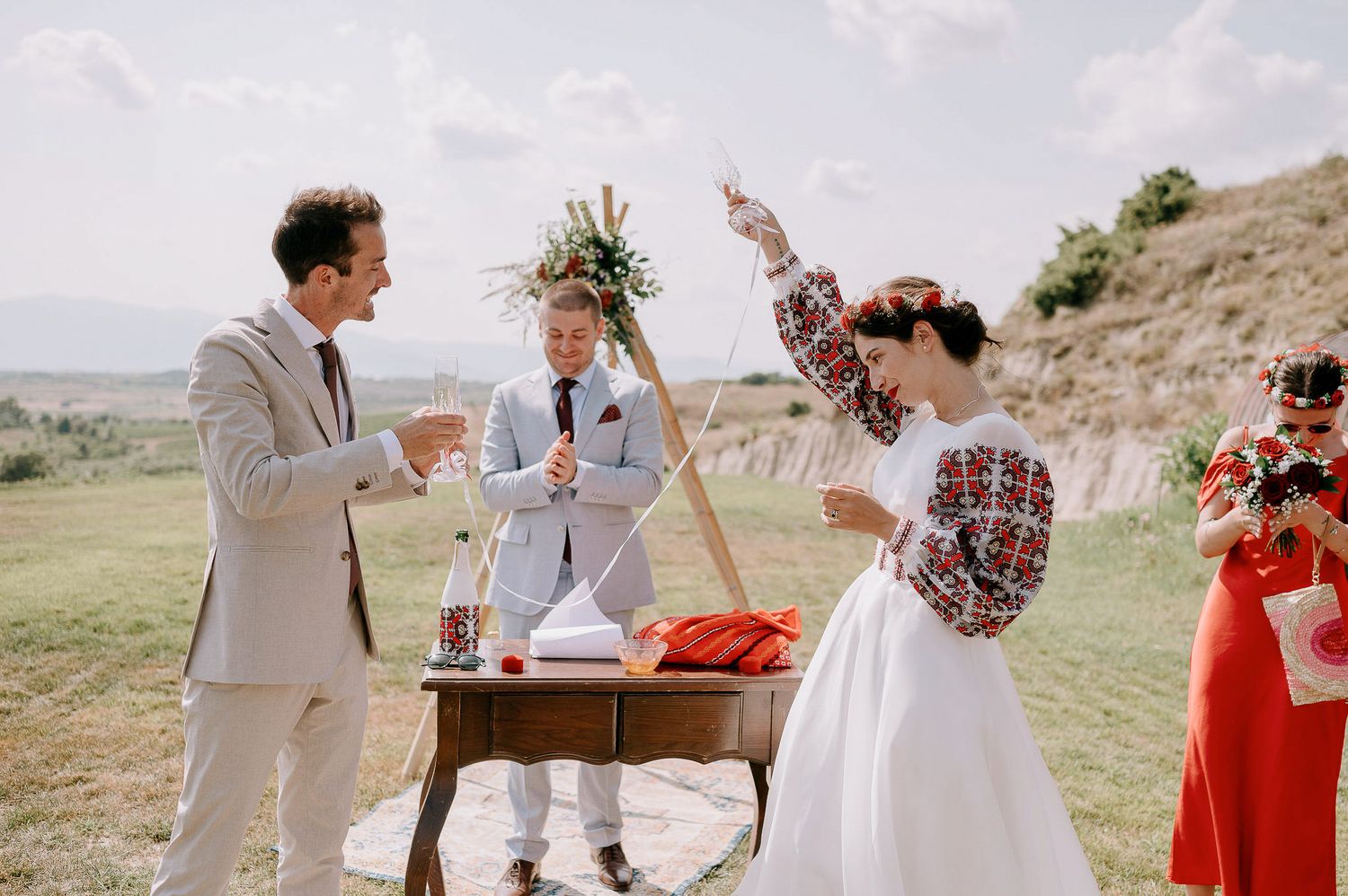 Outdoor wedding celebration with desert views featuring red and white color scheme.