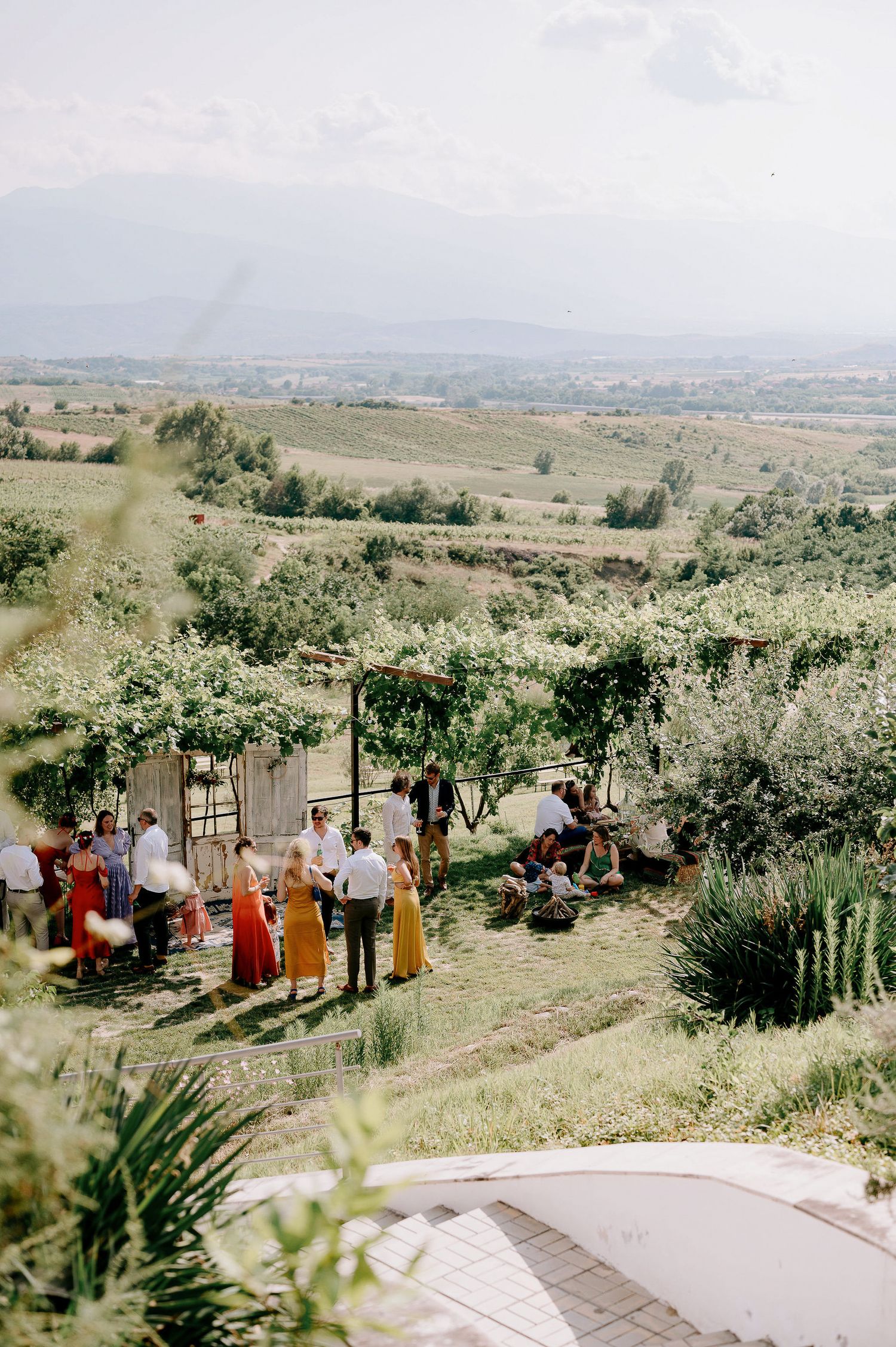 Wedding ceremony setup on a hilltop with guests enjoying the panoramic countryside views.