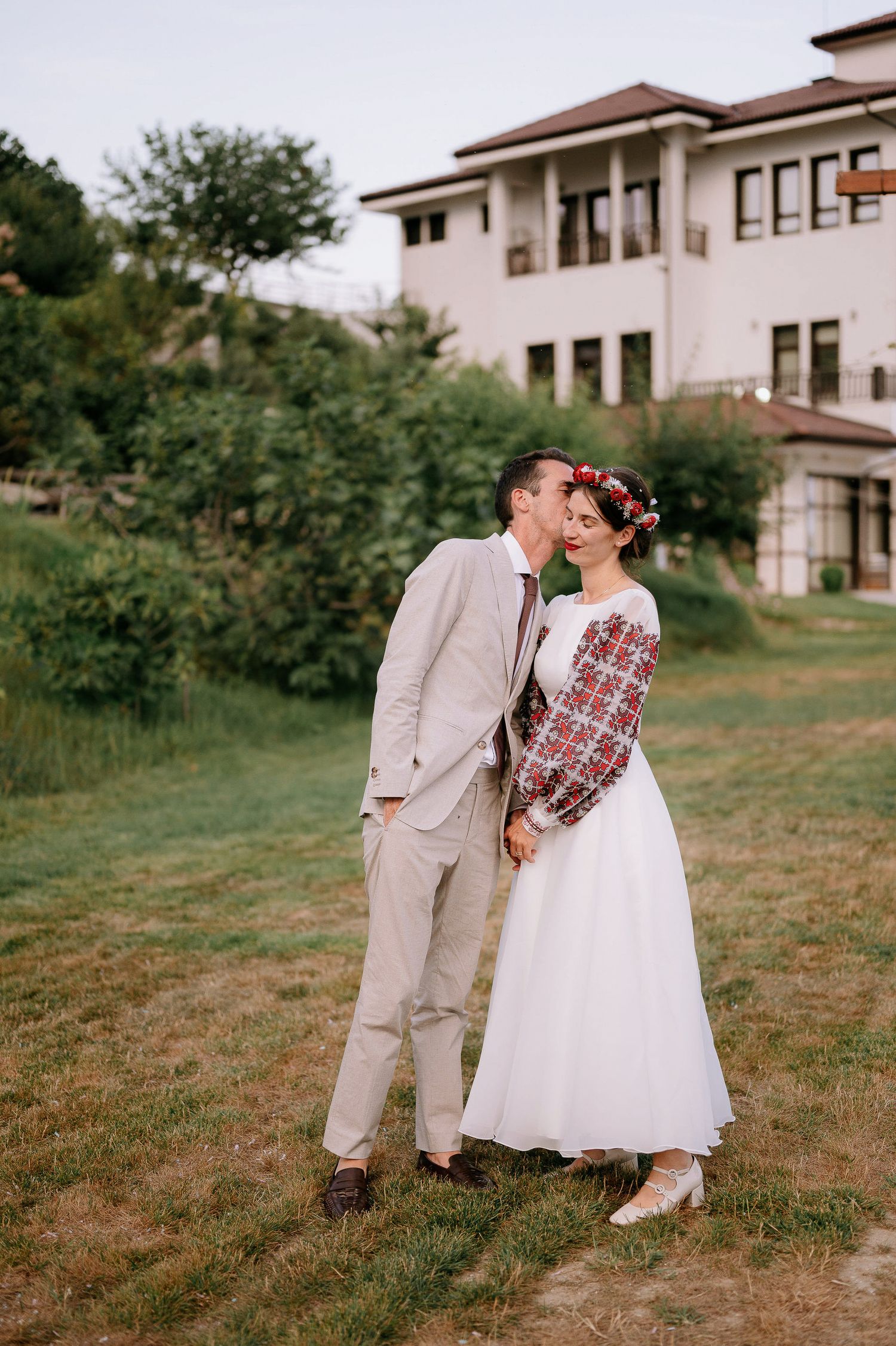 A sweet wedding moment between a couple in vintage attire with folk-inspired details.