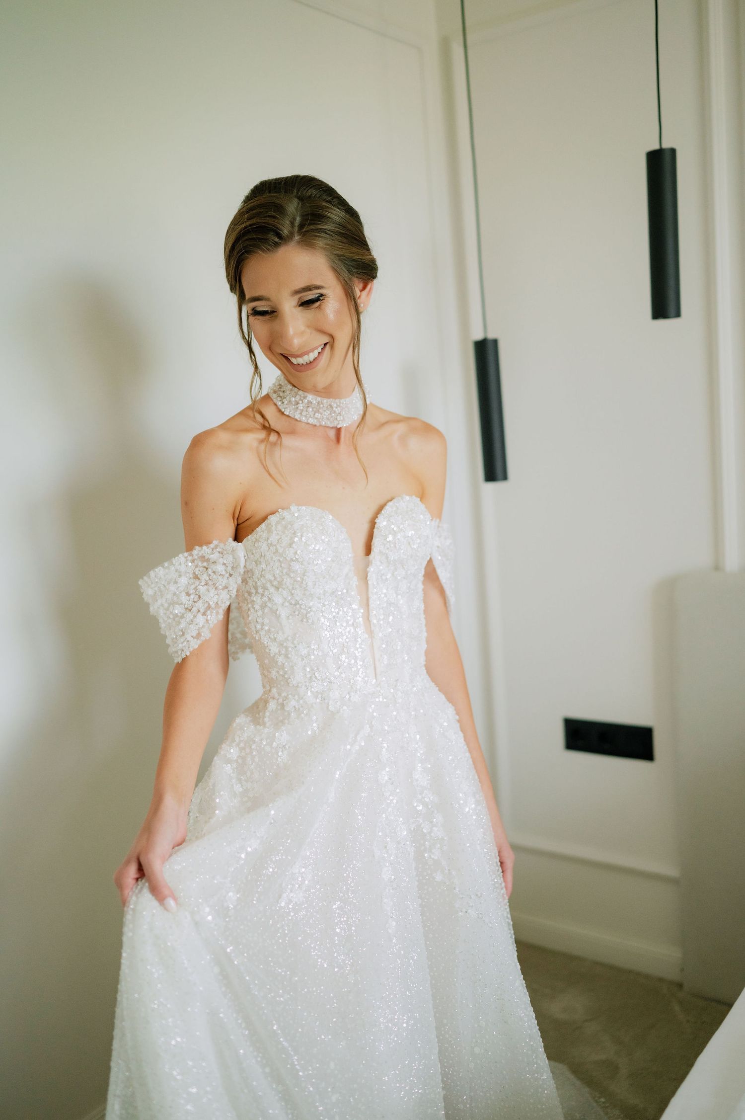 Candid moment of a bride twirling in her flowing white wedding gown.