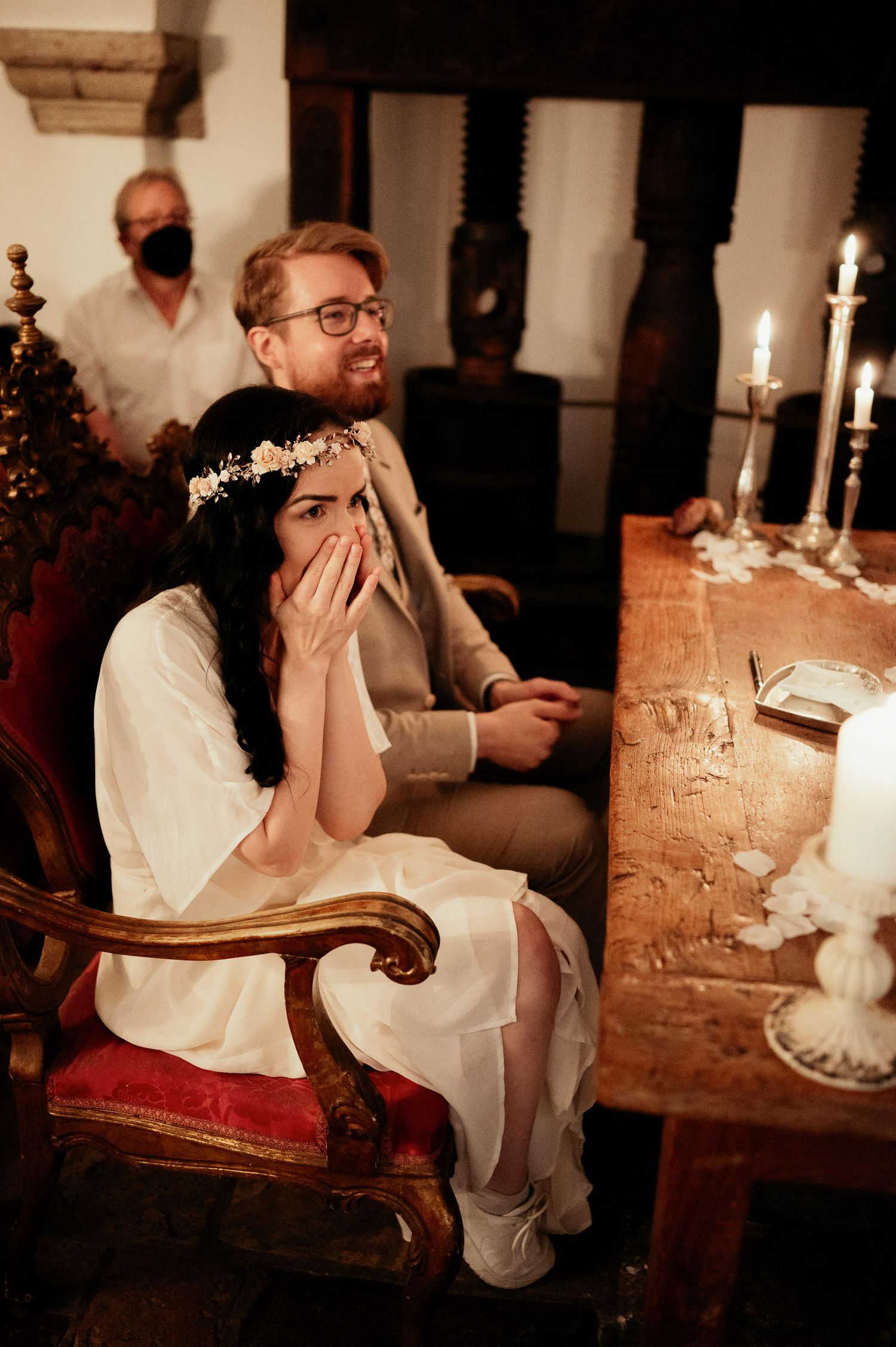 Emotional moment captured during intimate indoor ceremony with candlelight.