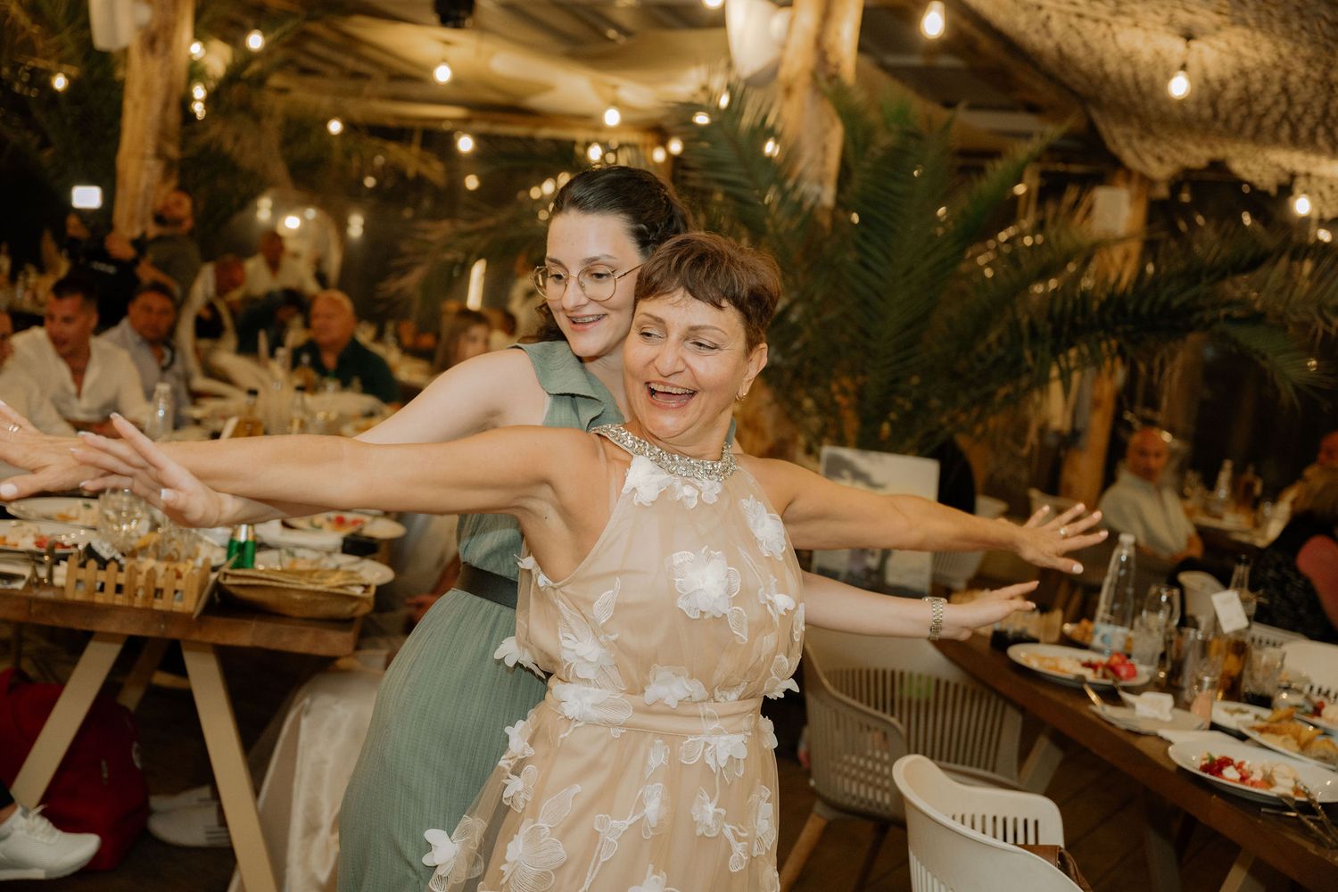 Guests dance and celebrate at a rustic barn wedding reception with warm lighting and wooden decor.