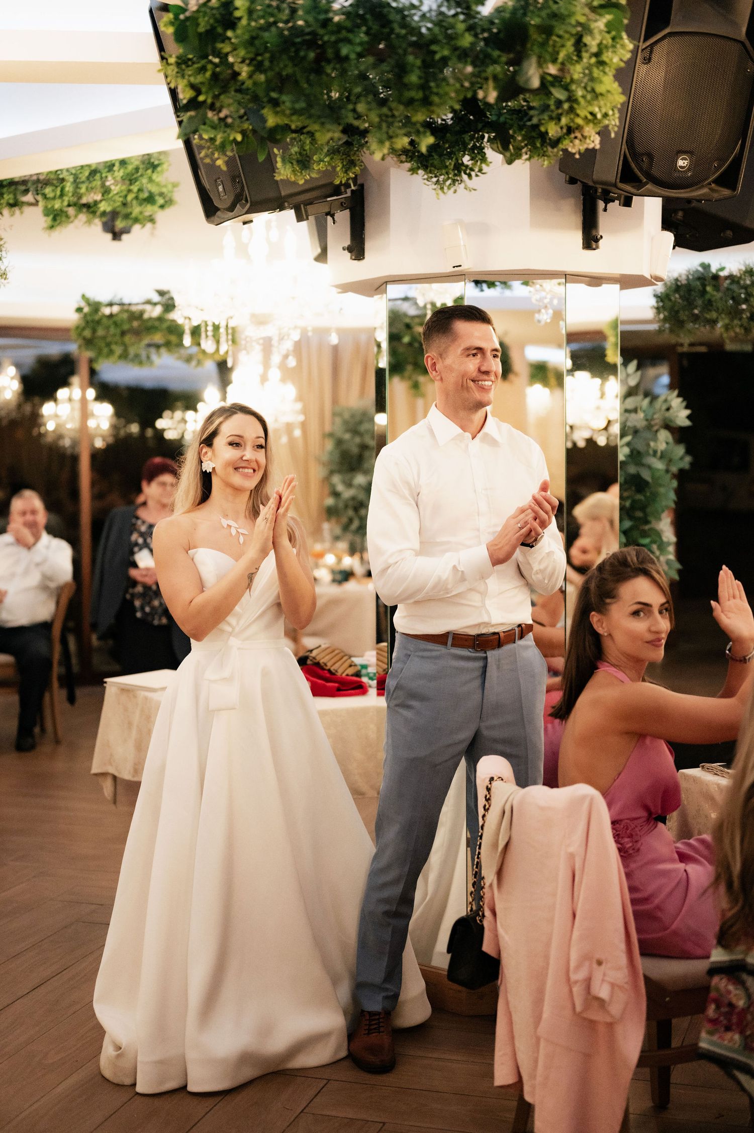 Wedding guests dancing and celebrating together on an outdoor covered patio during a reception.
