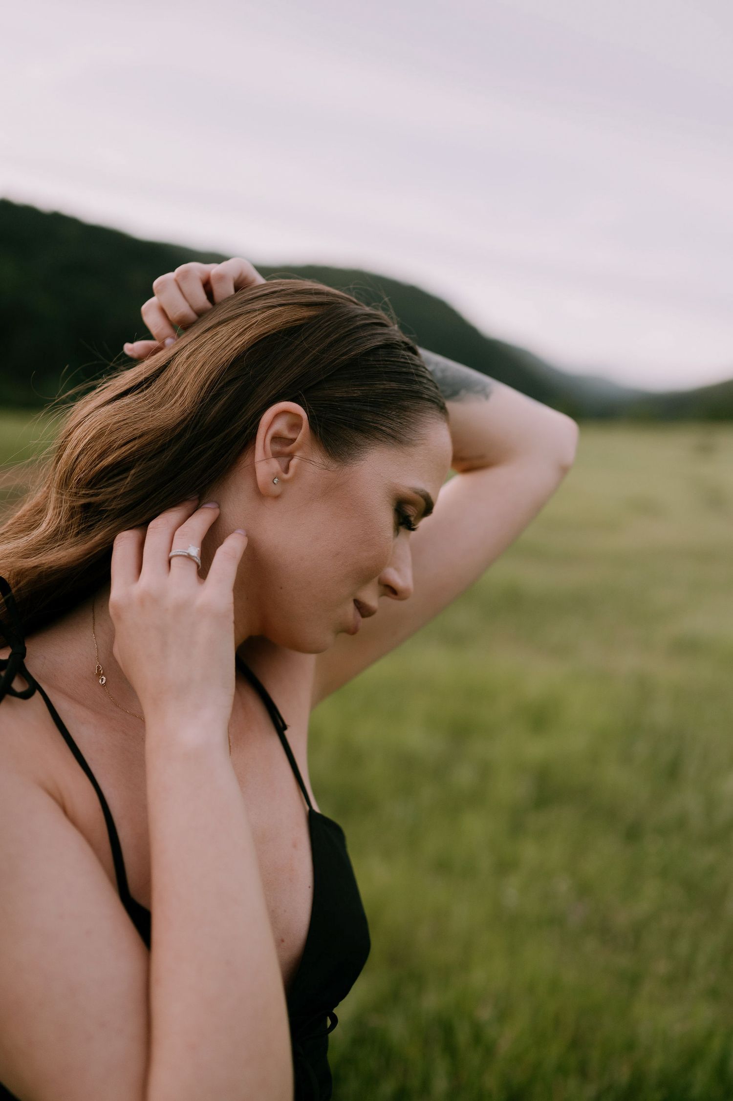 A series of artistic portraits showing a person with flowing hair in a black top against a soft natural outdoor setting.