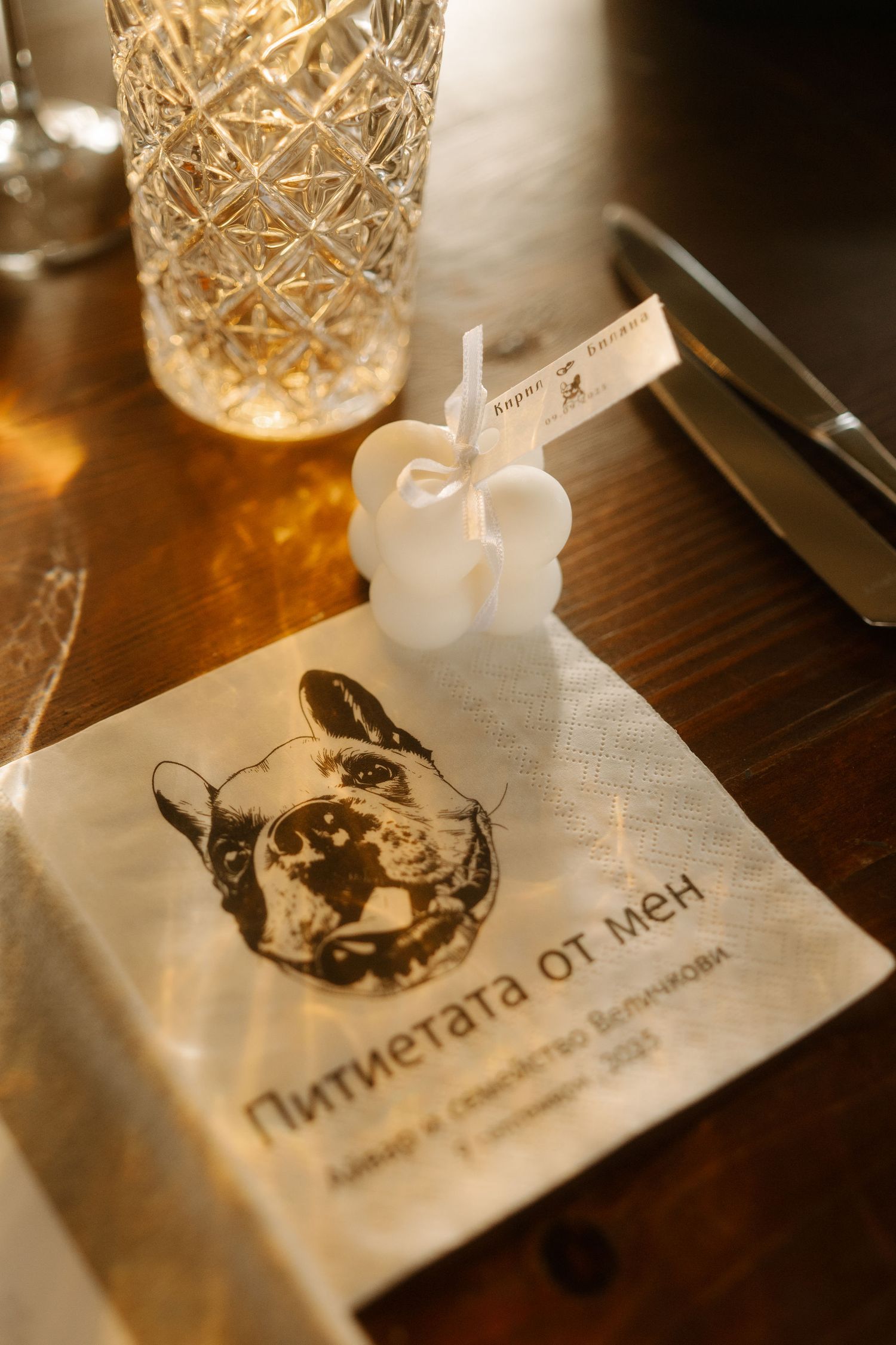 Elegant restaurant table setting with crystal glassware and branded menu cards in warm ambient lighting.