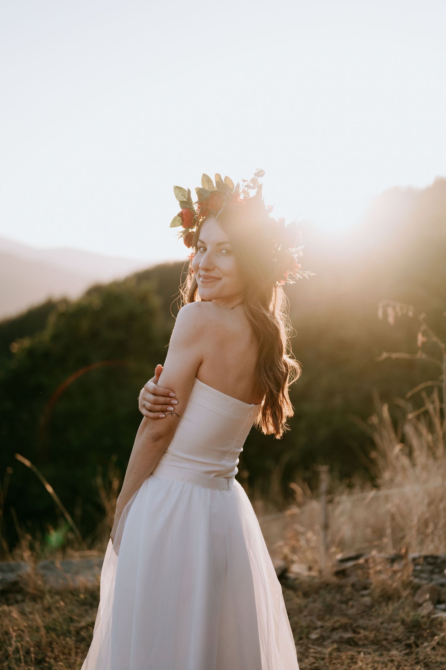 Romantic sunset portrait featuring a flowing white wedding dress in nature.
