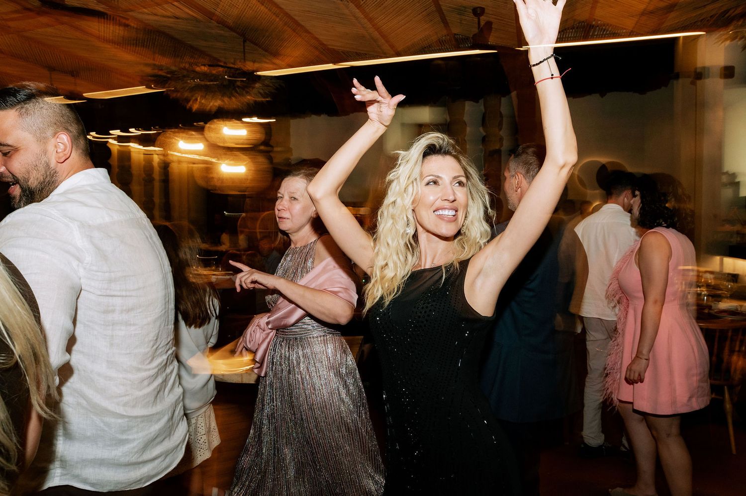 Dynamic dance floor scene with party guests celebrating under ambient lighting.
