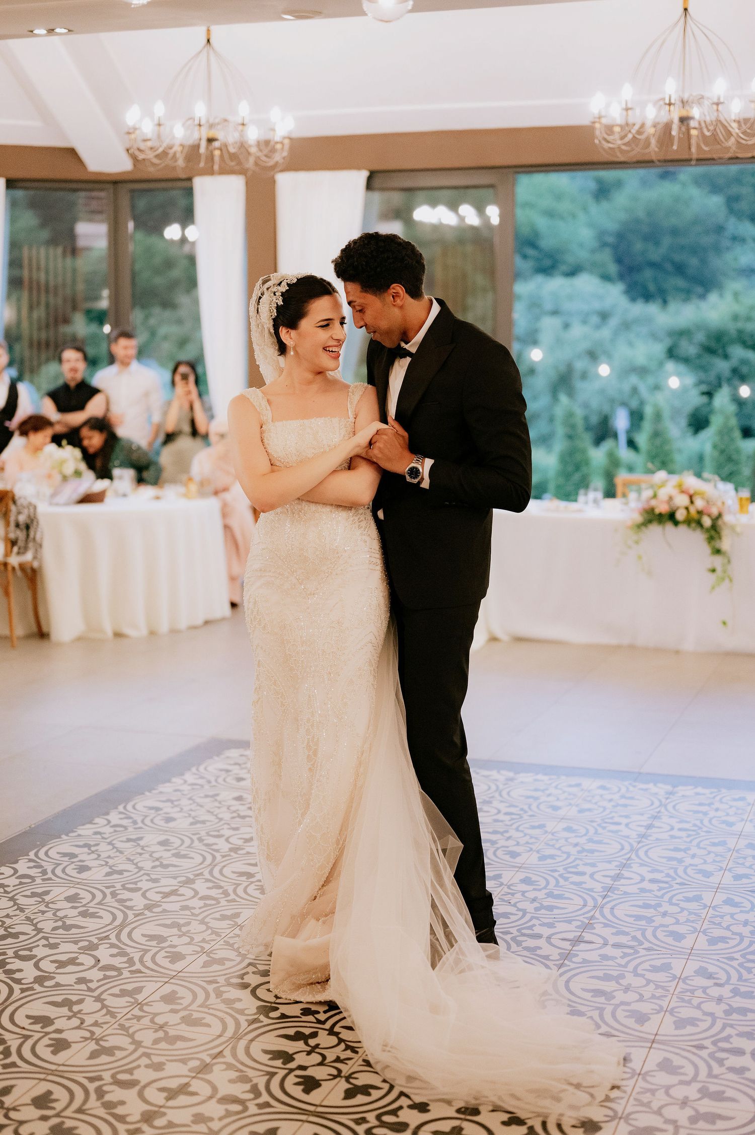 Couple shares an intimate moment during their first dance in an elegant ballroom.
