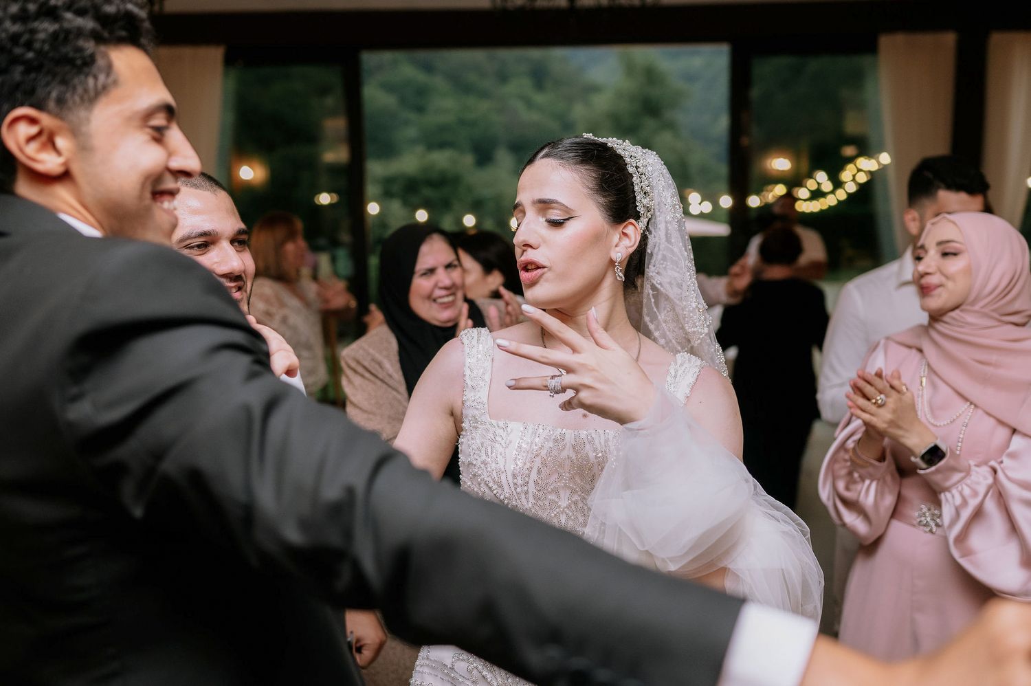 Wedding party dancing and celebrating during reception in elegant indoor venue.
