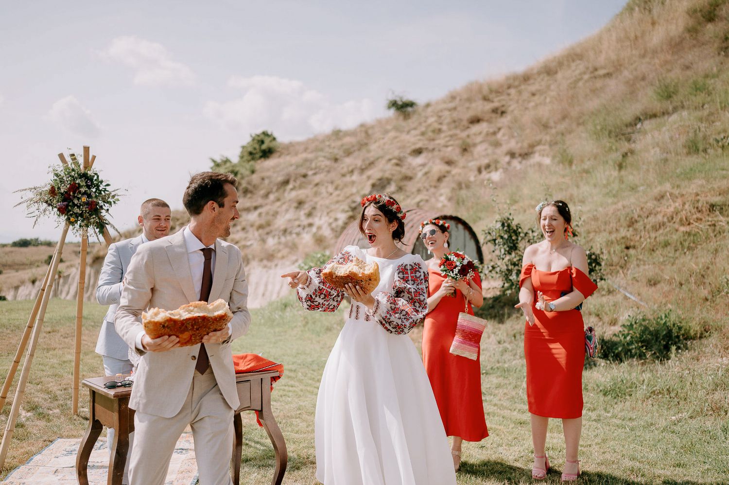 Outdoor wedding celebration with bridal party in coral and white attire.