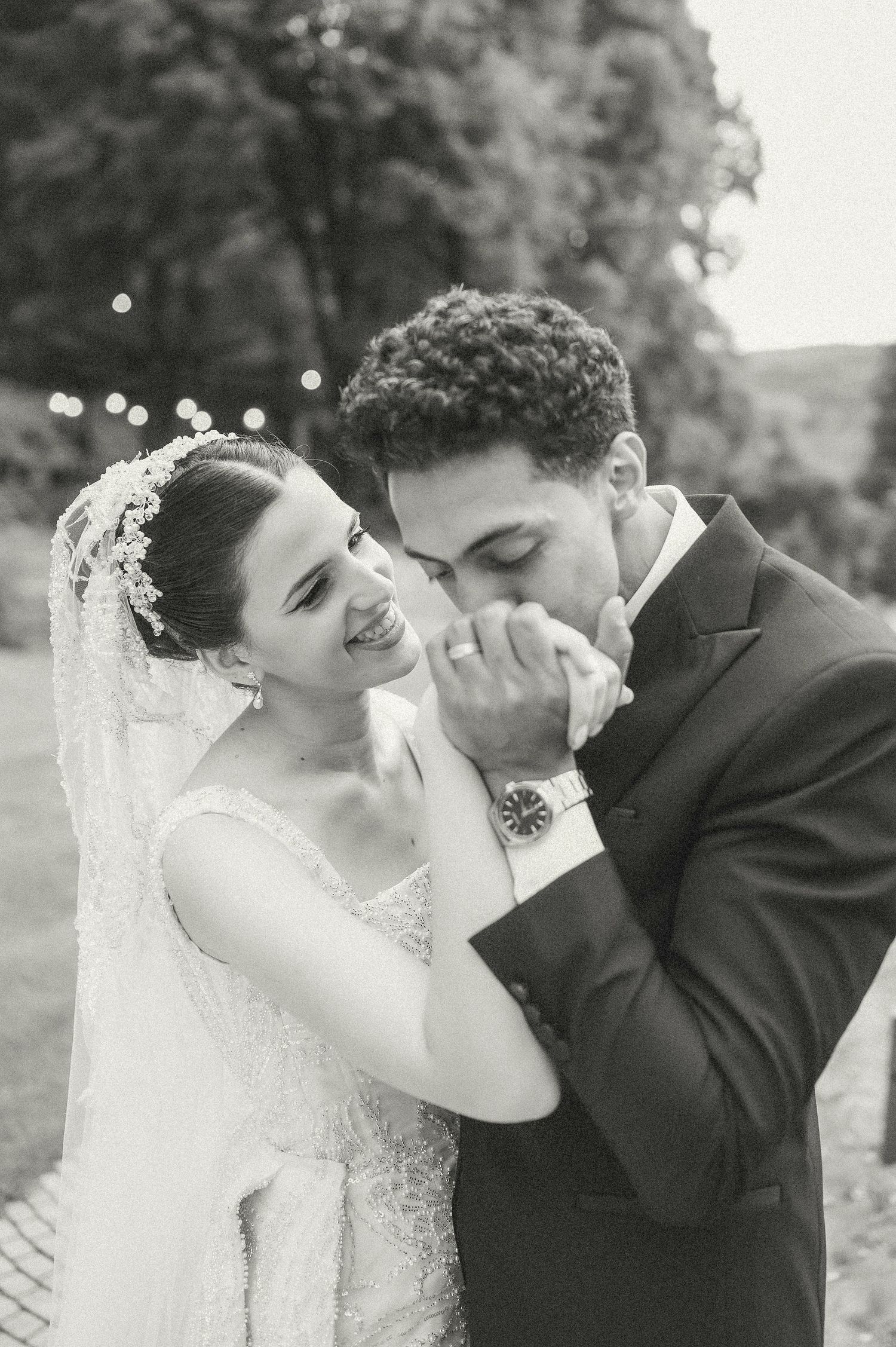 Black and white wedding photos capture tender moments between newlyweds in an outdoor setting.