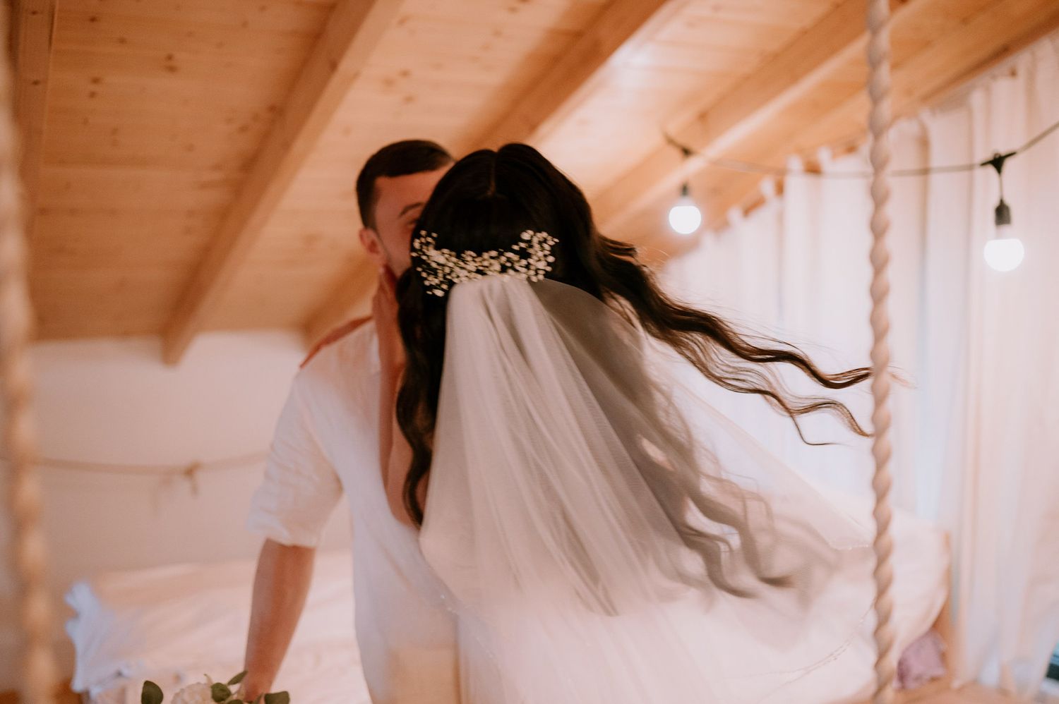 Whimsical bridal session with hanging decorations and wooden beam ceiling.