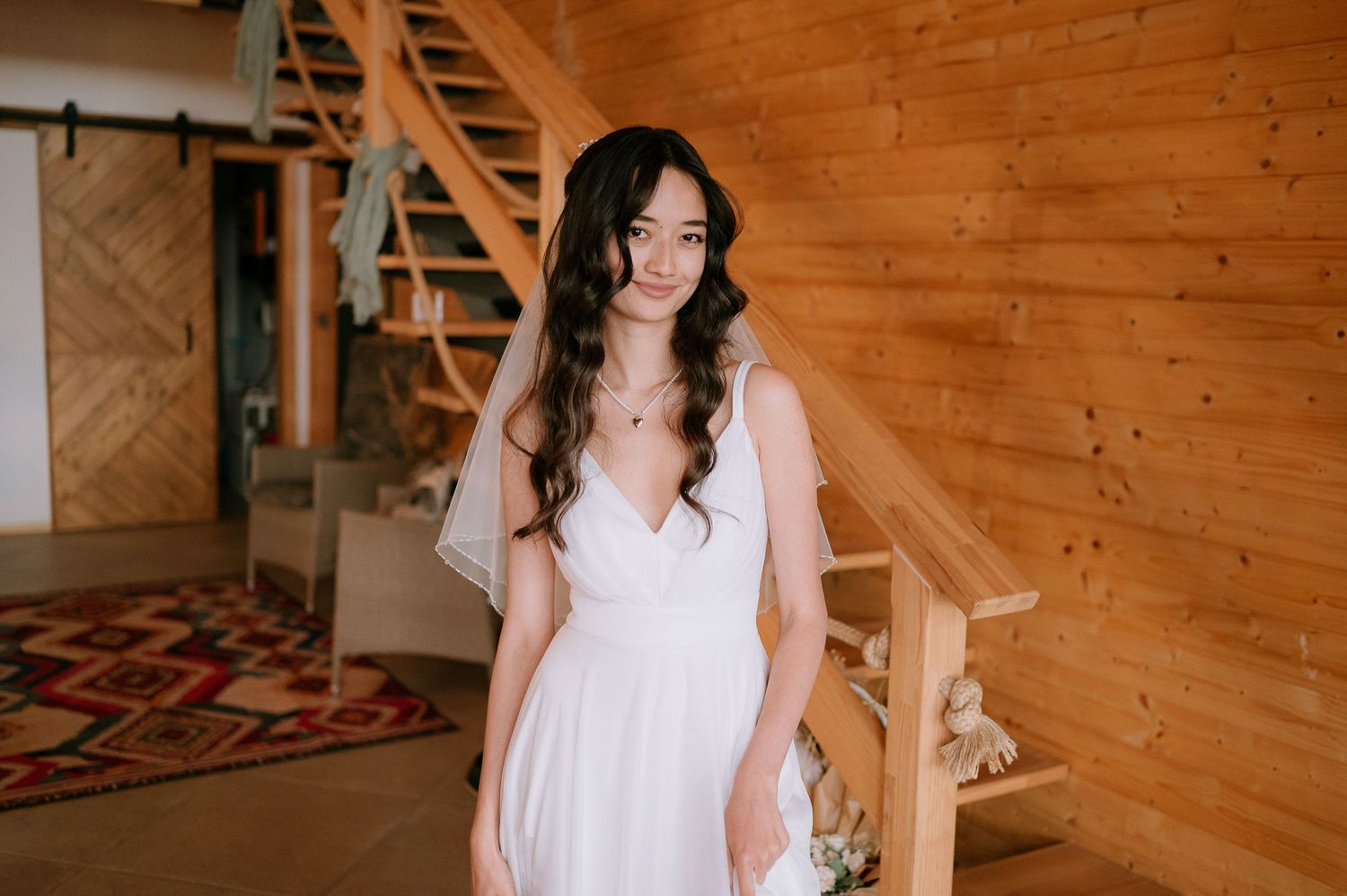 Elegant white dress photographed in rustic cabin setting with natural lighting.