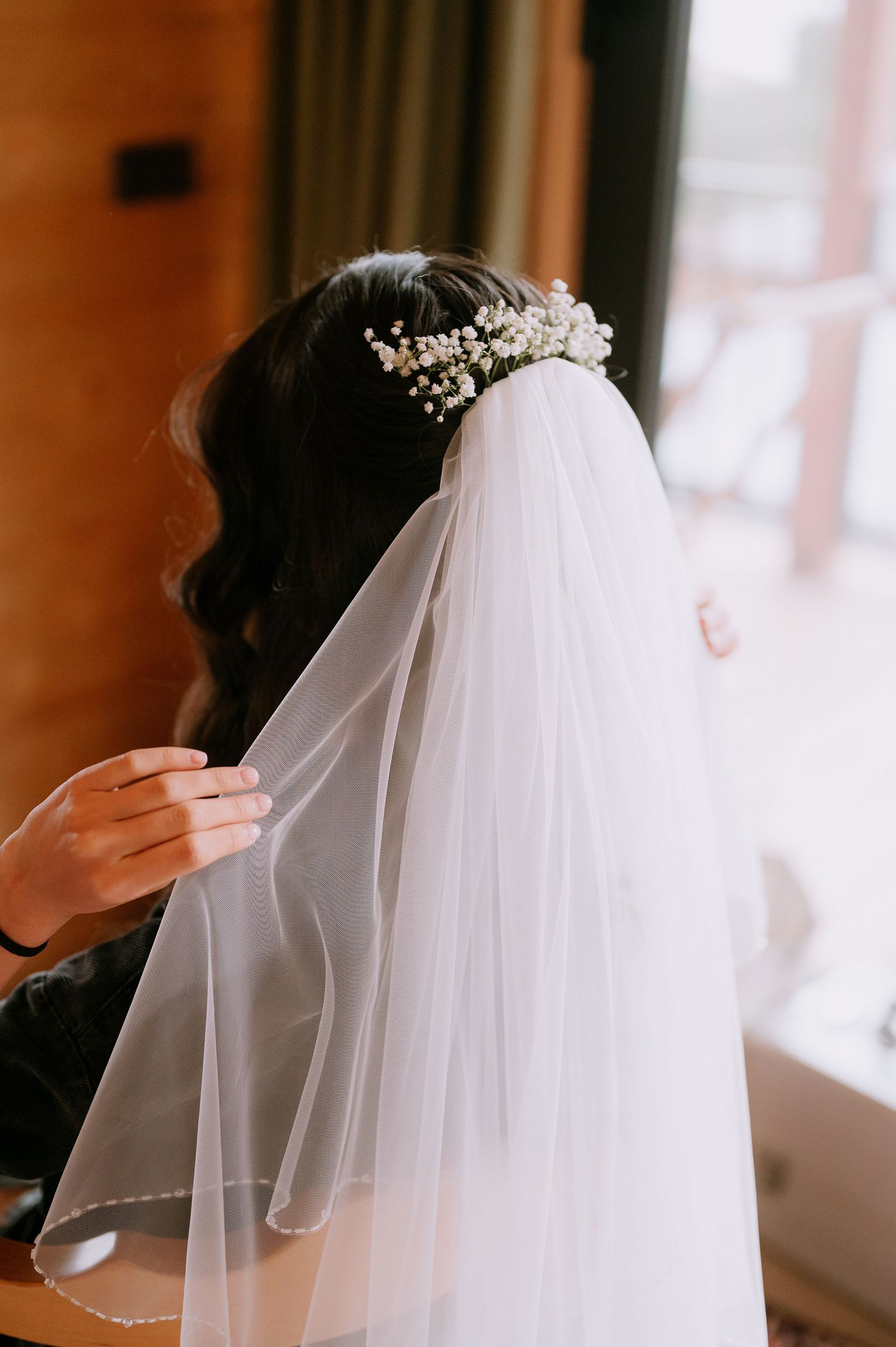 Delicate white bridal veil with lace details in soft natural lighting.