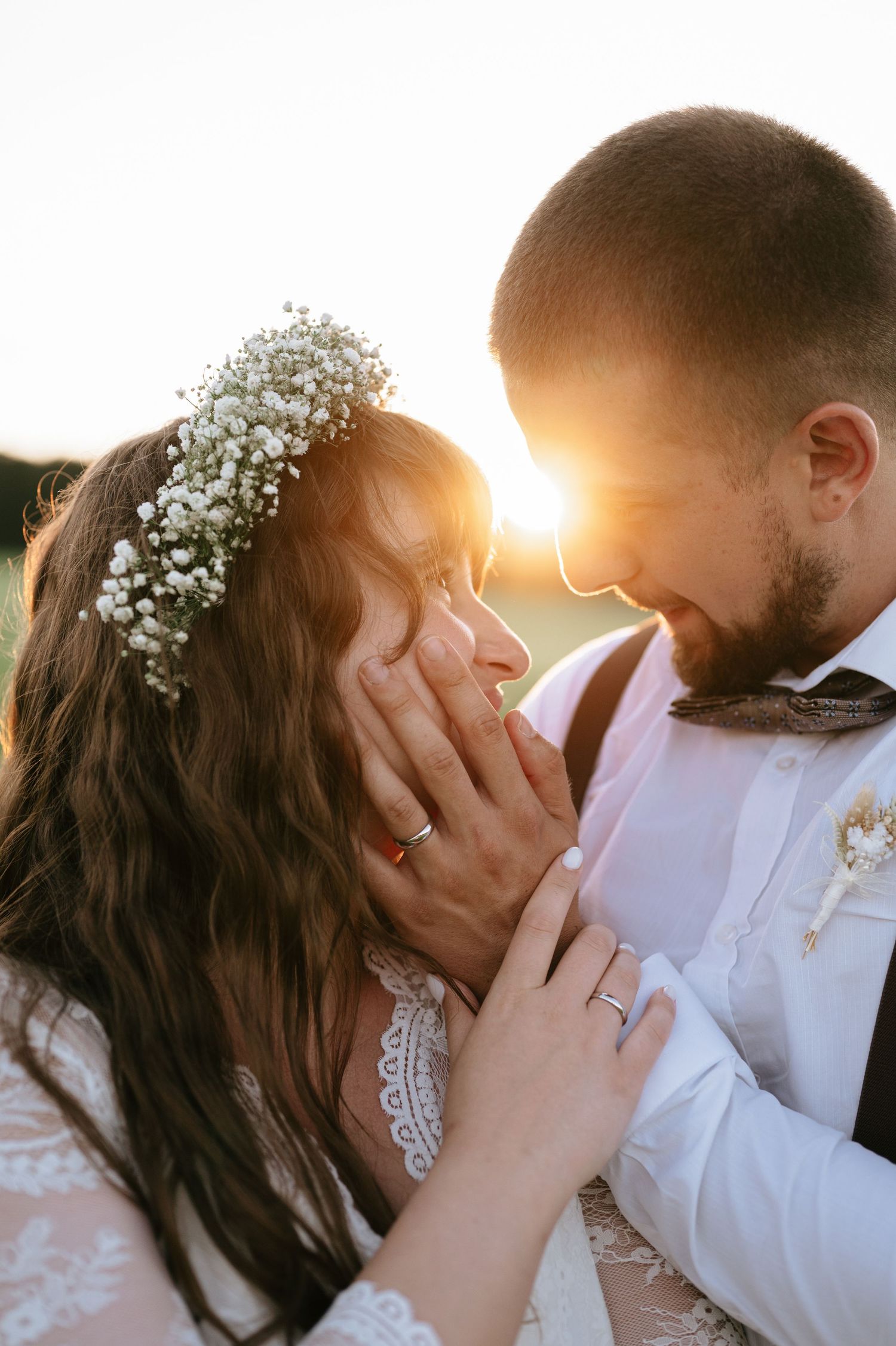 Newlyweds share intimate moment during golden hour wedding photoshoot.