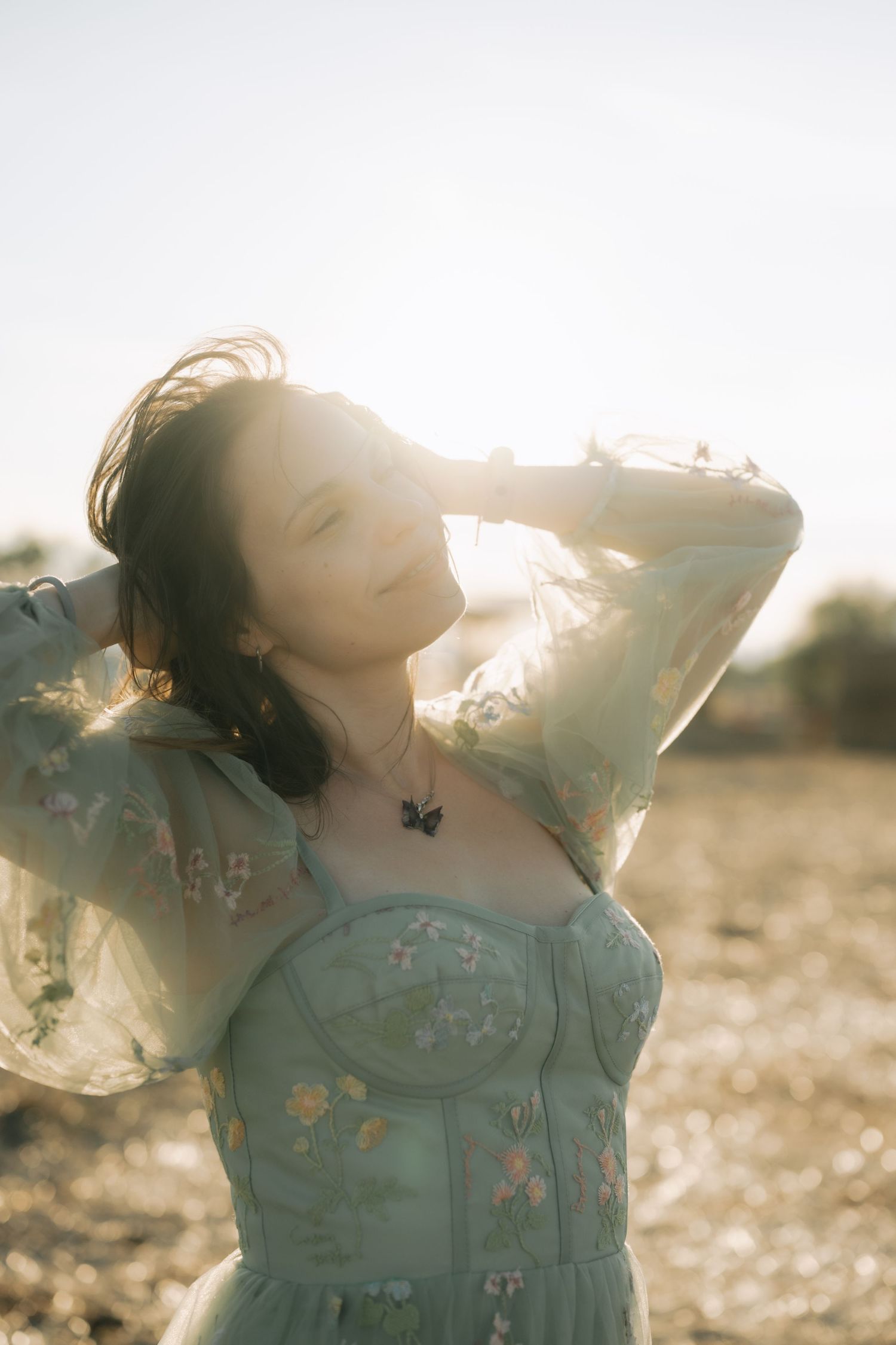 A dreamy portrait of someone in a blue dress twirling in golden sunlight with a soft, ethereal quality.