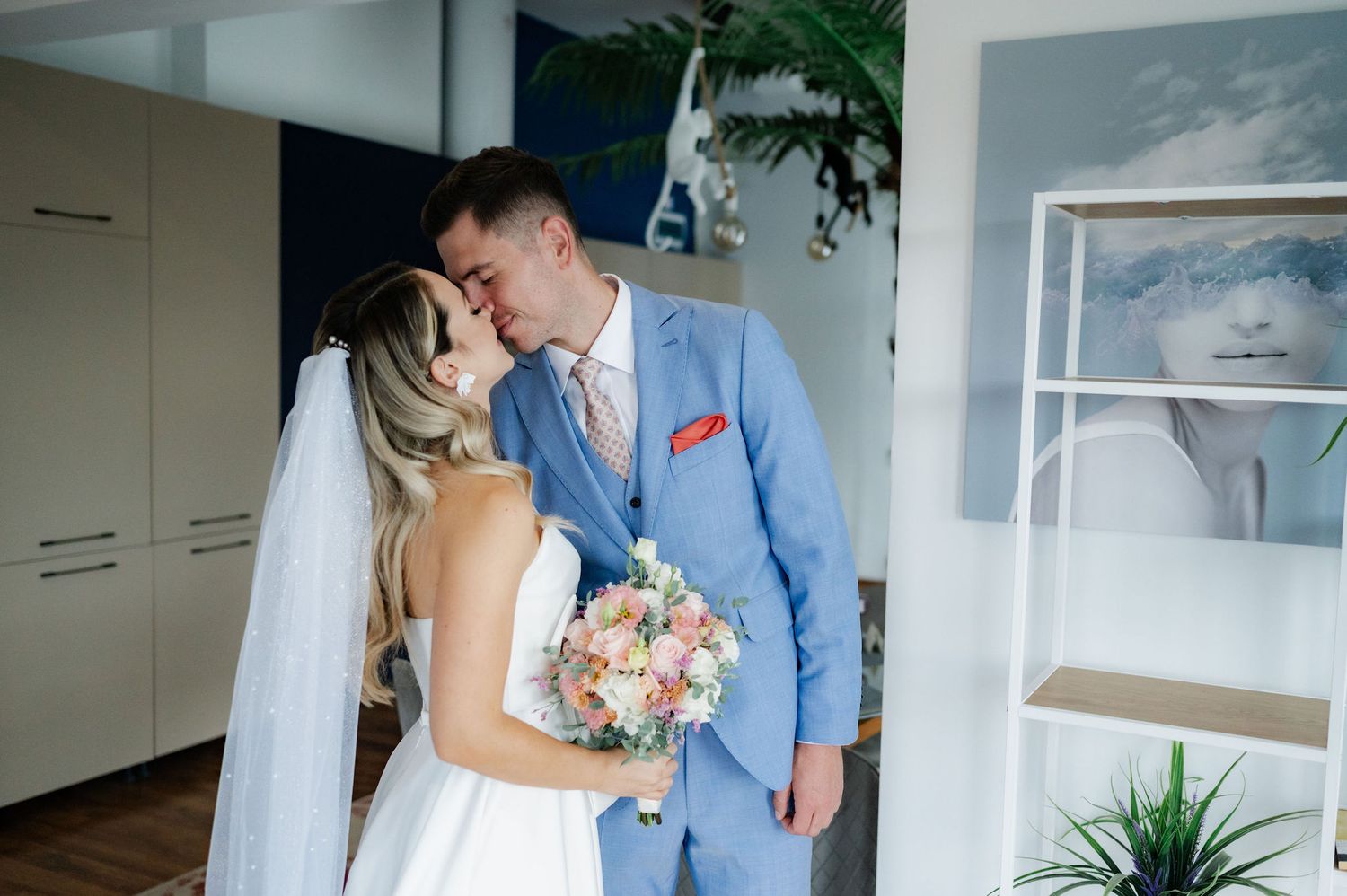 A couple shares an intimate moment during their wedding celebration in a bright, modern venue.