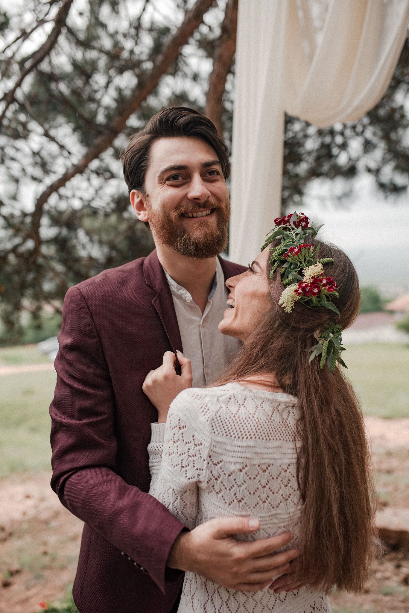 A romantic couple shares intimate moments in a series of outdoor wedding photos with rustic decor and floral details.