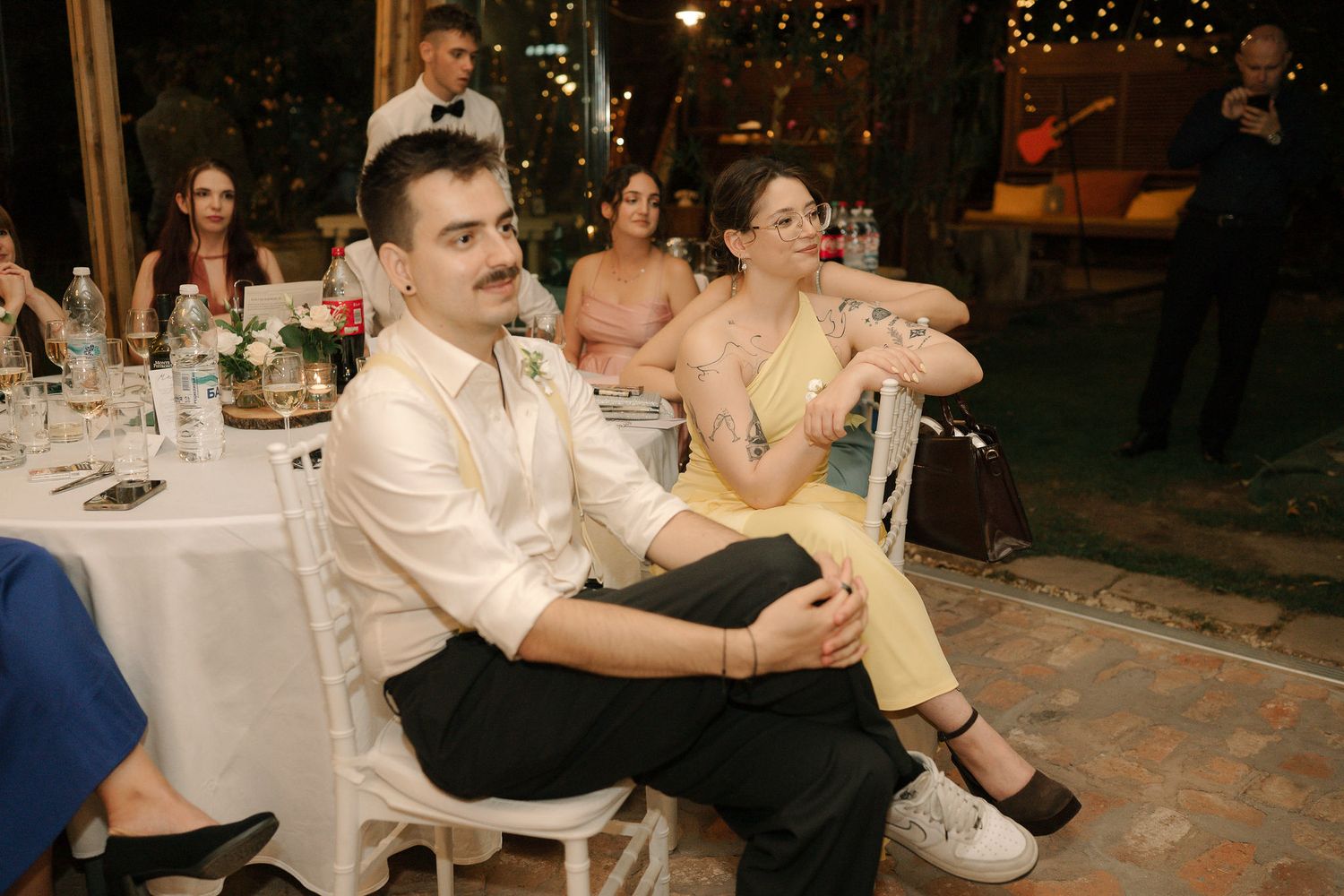 Wedding guests dance together during a lively reception celebration at an elegant indoor venue.